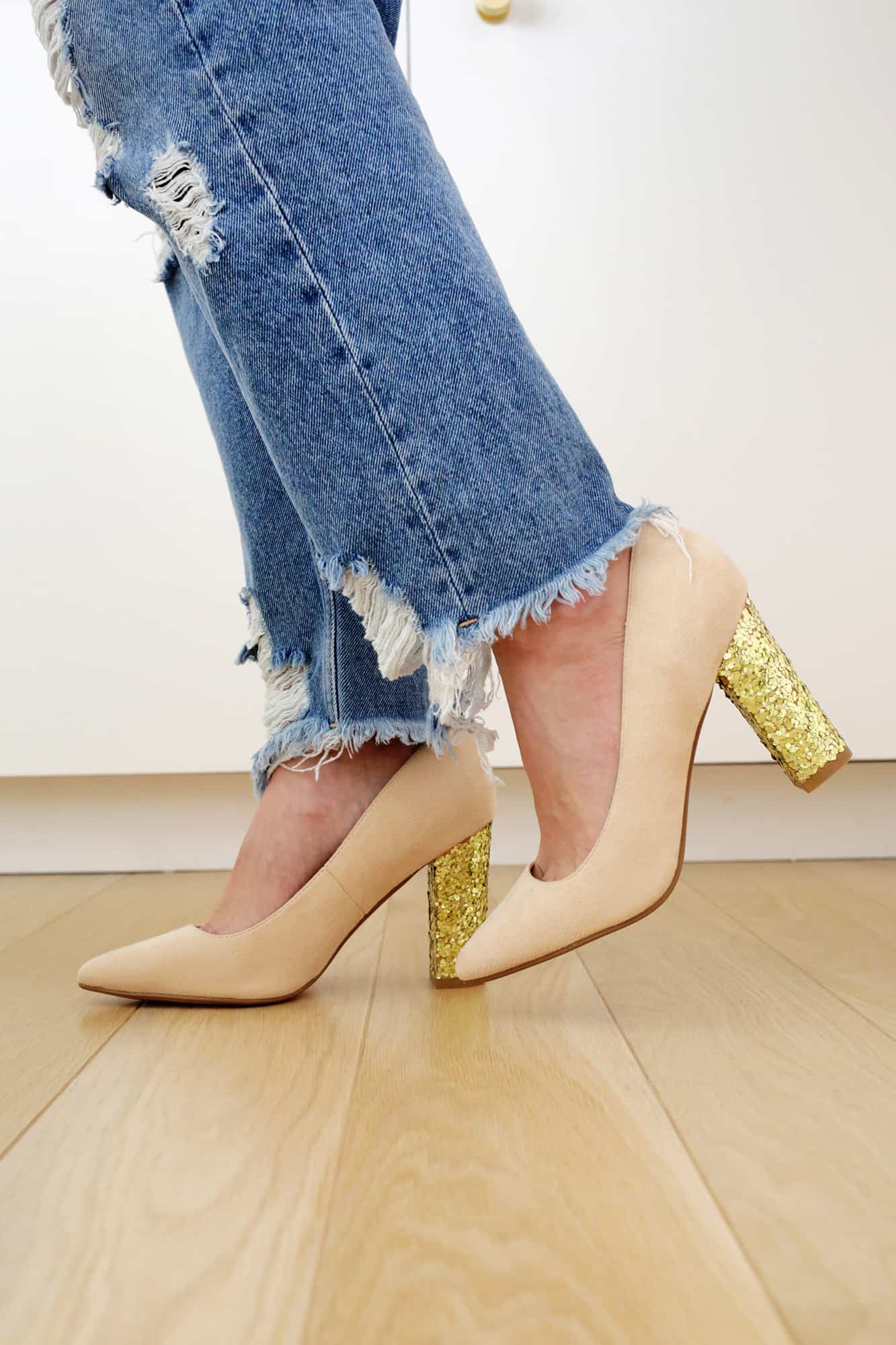 Mulher vestindo sapatos com saltos dourados brilhantes
