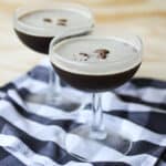 two espresso martinis garnished with coffee beans.