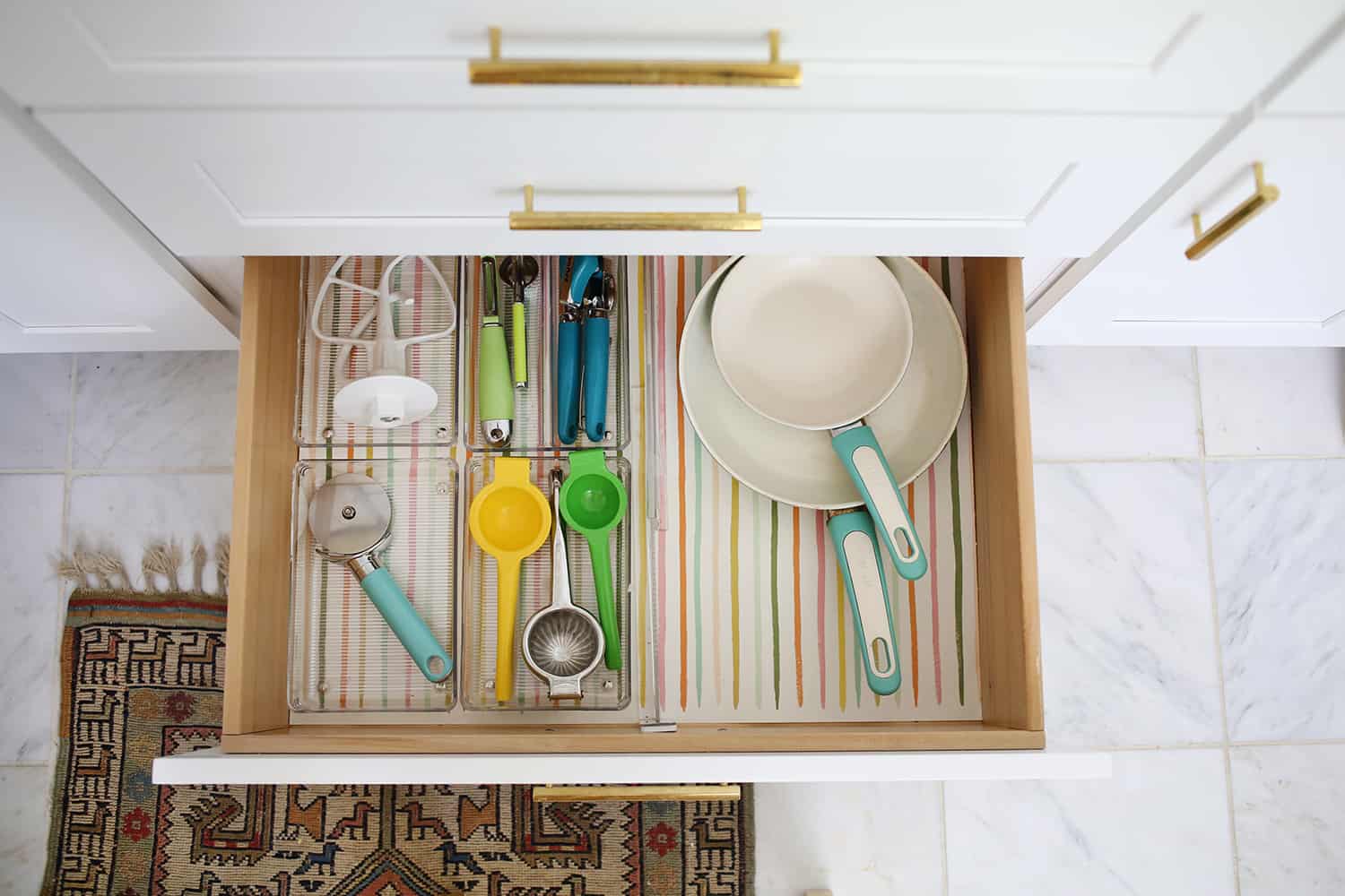 drawer with clear containers holding utensils and 2 pans in it