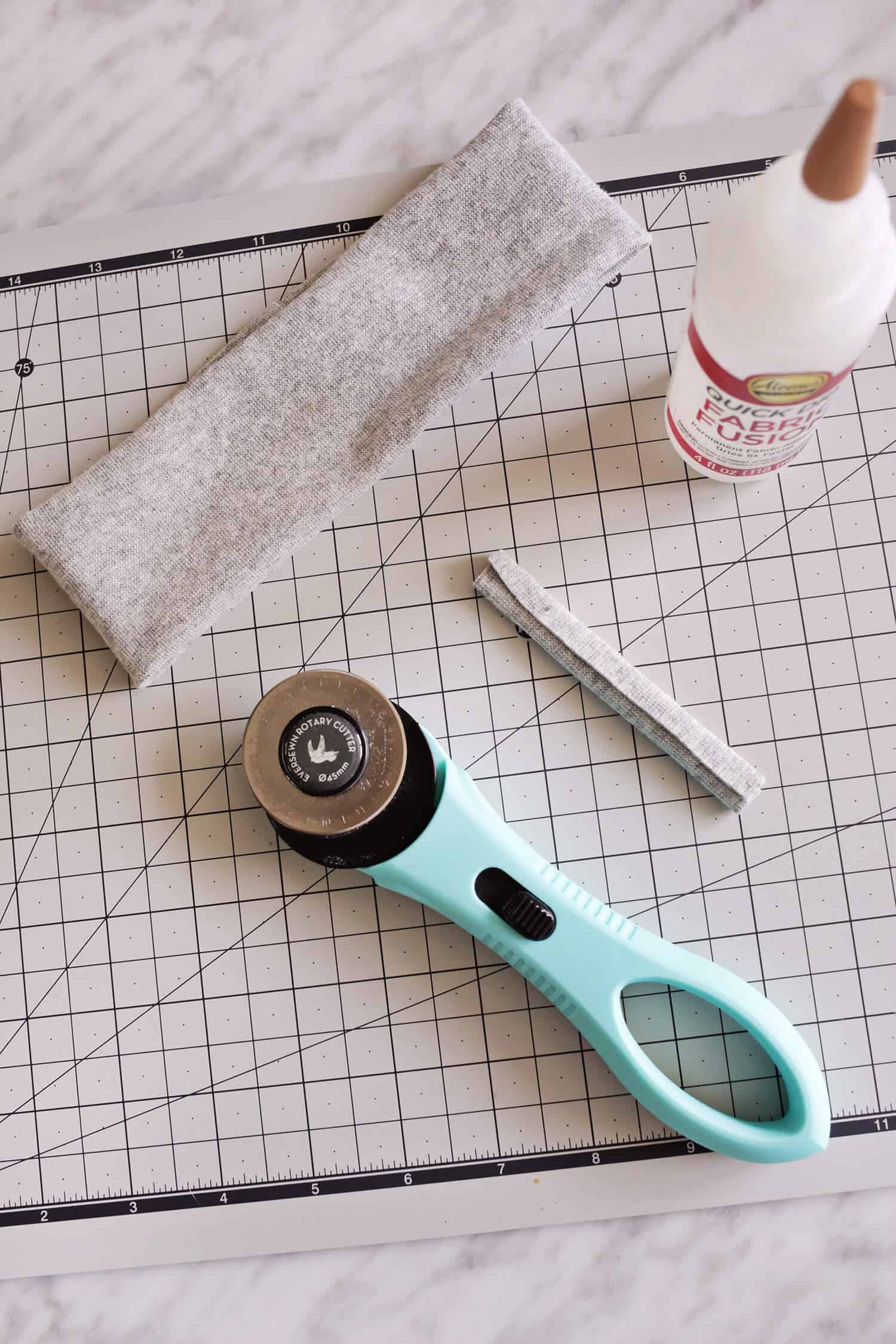 rotary cutter, glue and fabric on mat