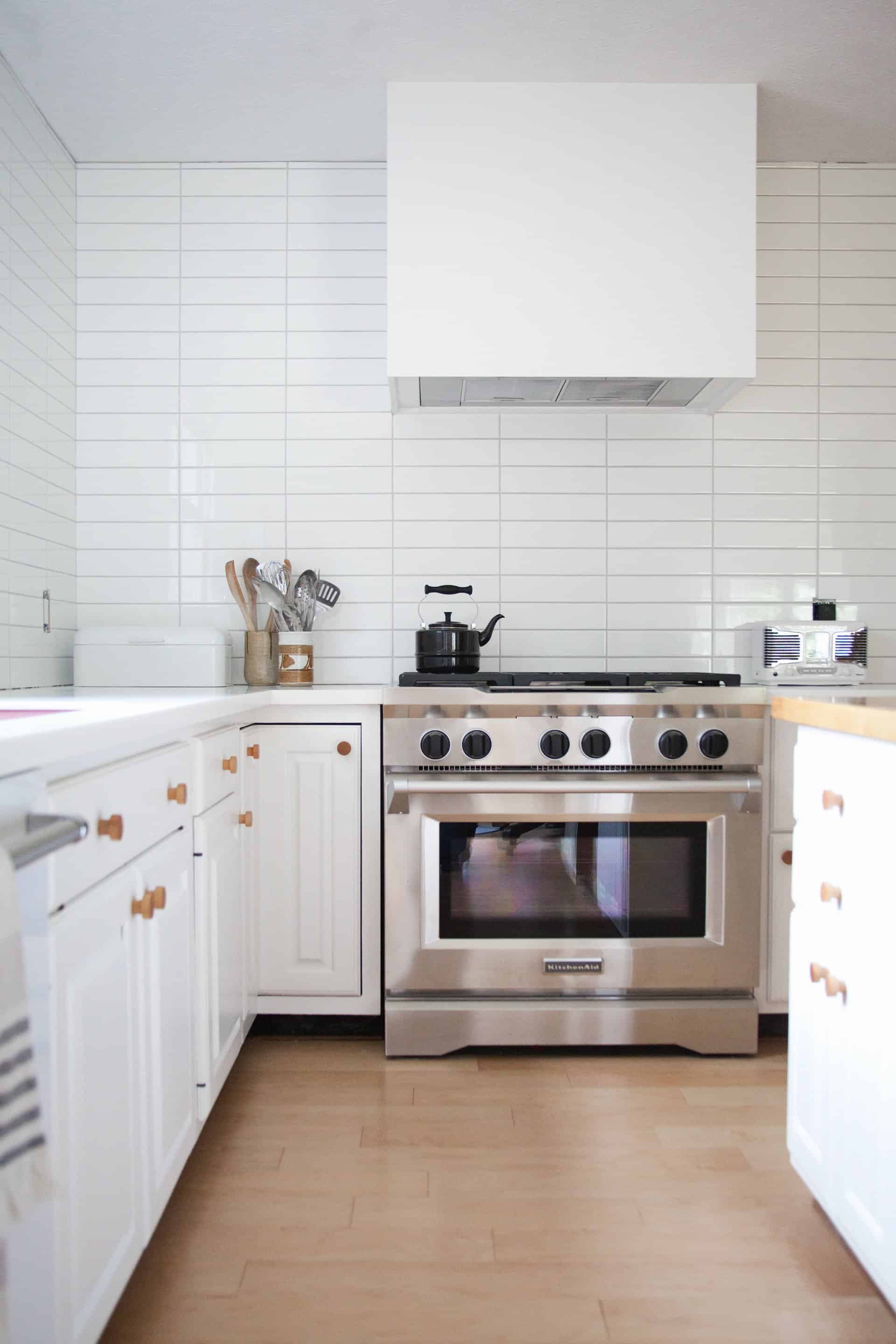 kitchen with white cabinets, white countertop, and white tile