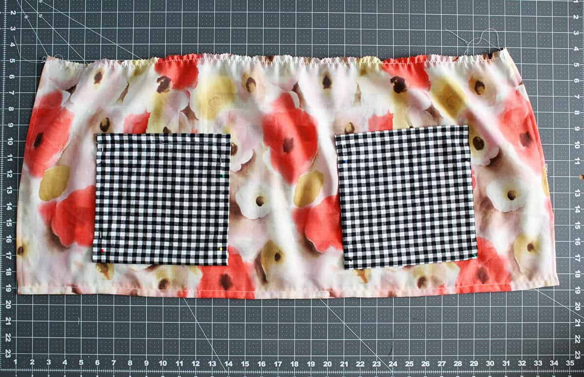 flower fabric with 2 black and white checkered square pieces of fabric laying on it