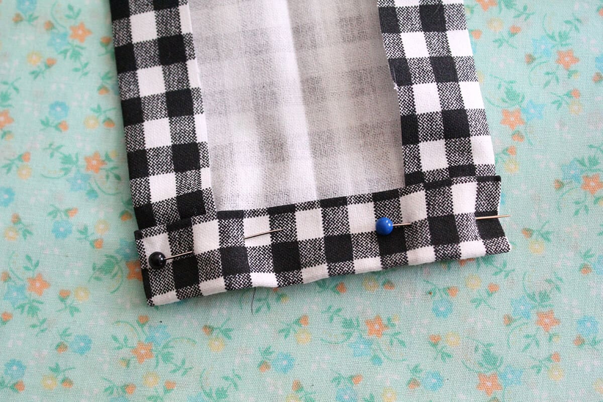 black and white checkered fabric with the hem pinned
