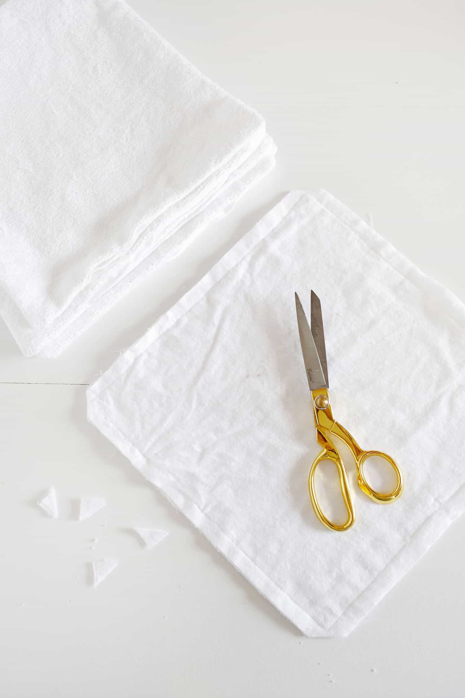 several pieces of cotton fabric with gold scissors on top