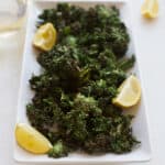 plate of kale chips with lemon wedge