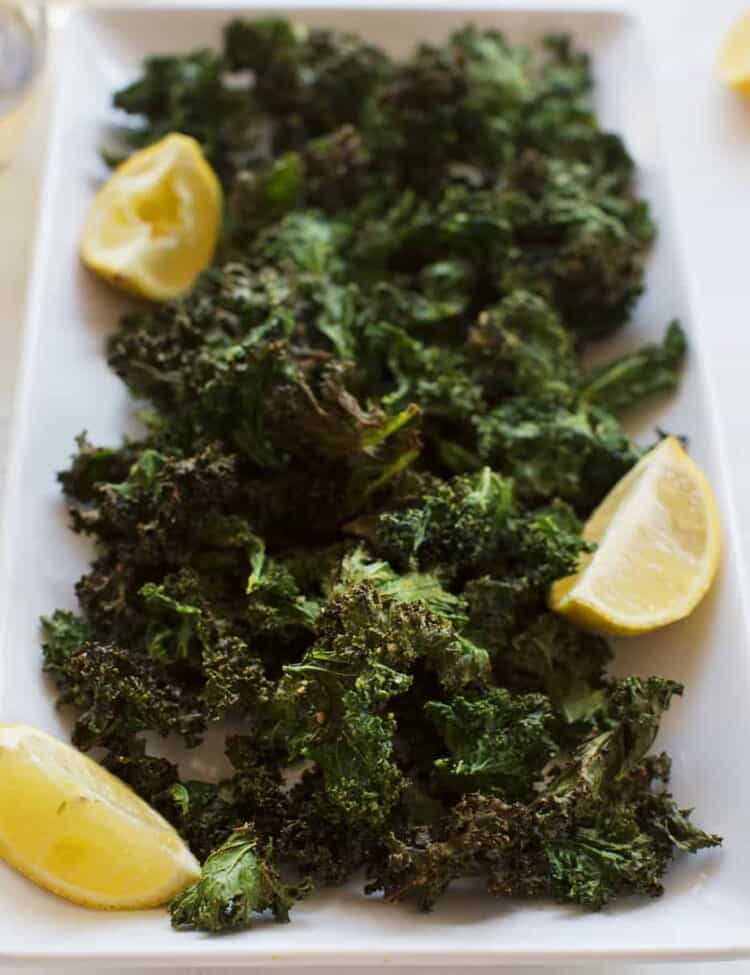 plate of kale chips with lemon wedge