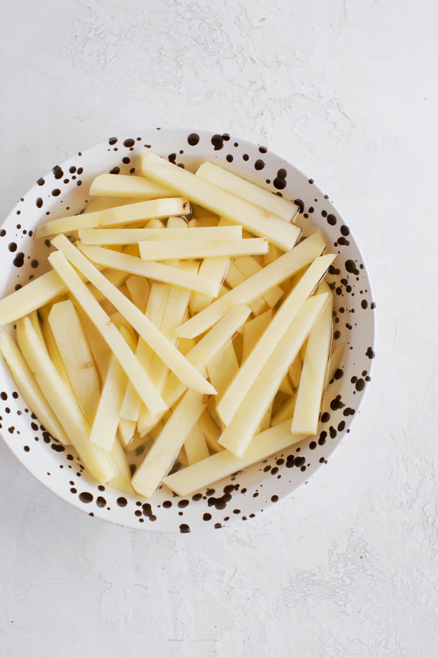 cut up strips of potato in a bowl