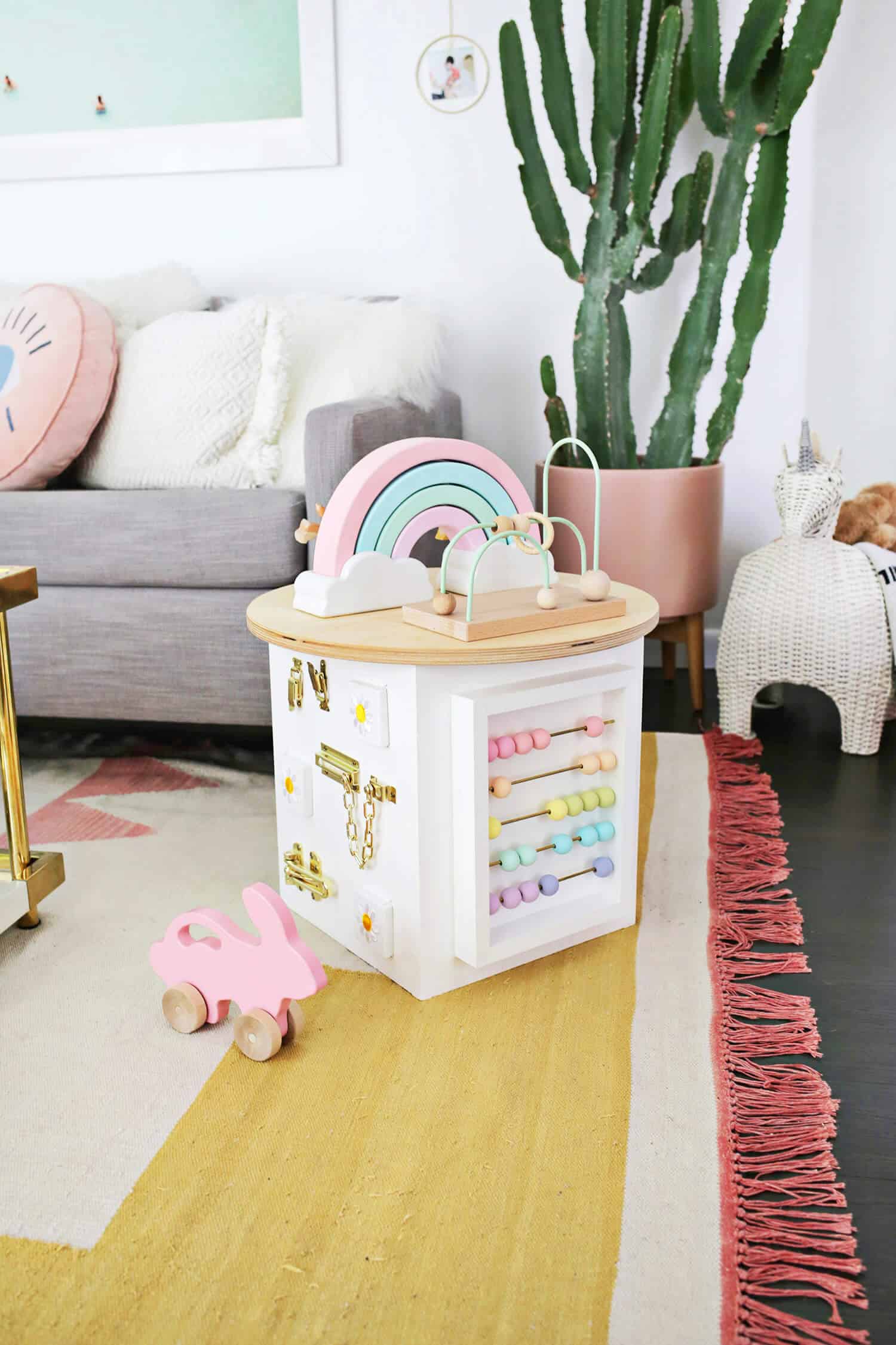 toddler activity center with a rainbow on top in a living room