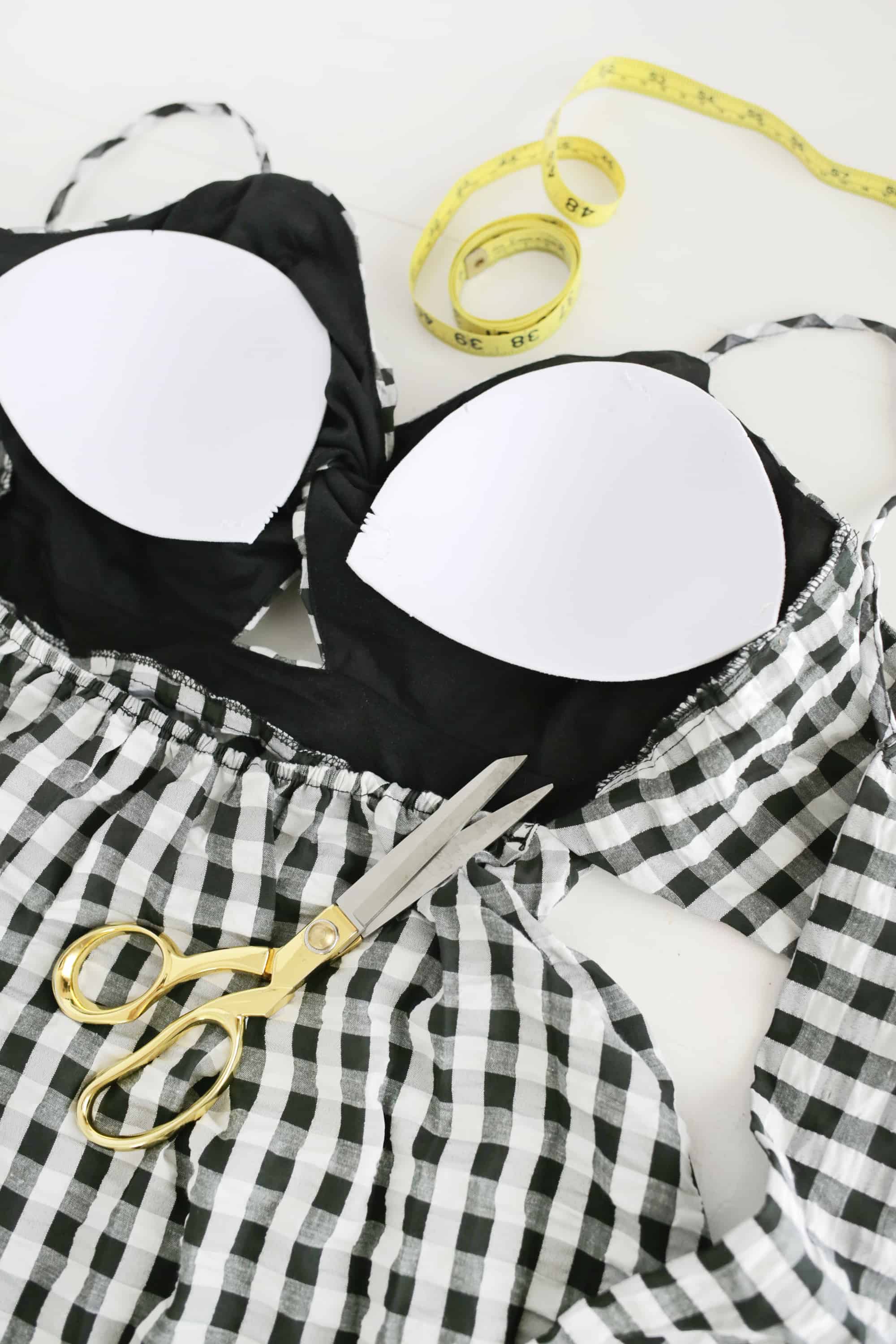 bra cups sewn into black and white checkered dress with gold scissors laying on top of it