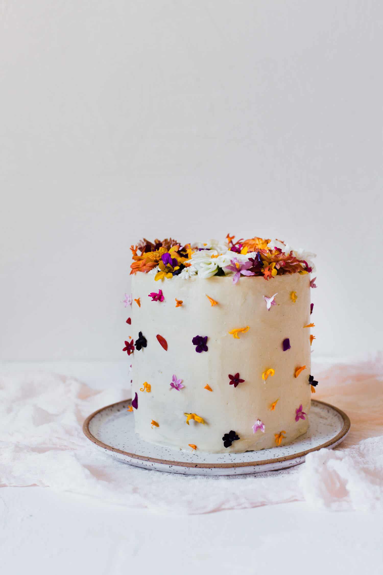a white cake with edible flowers on it