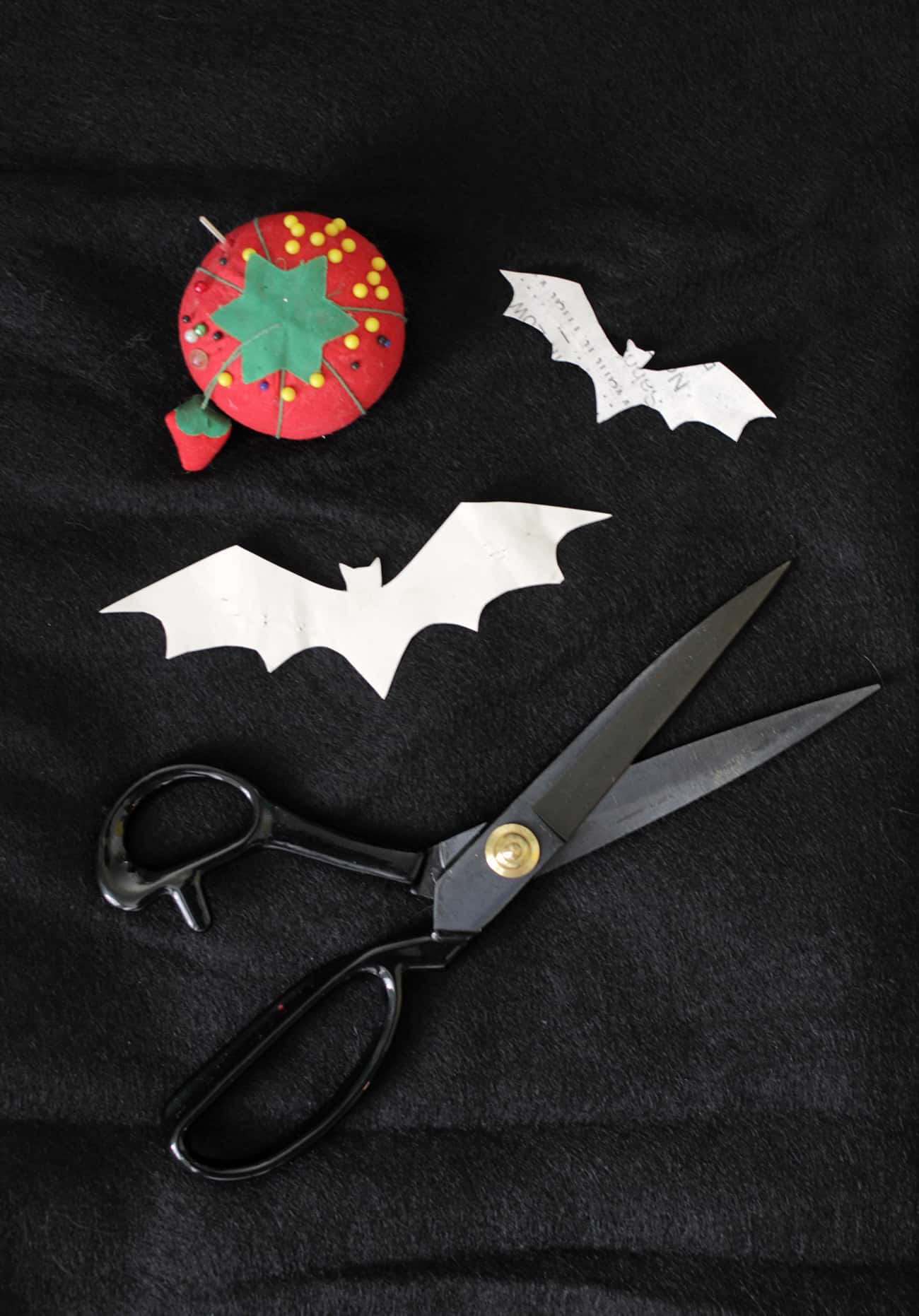 bat patterns cut out of crafting felt with fabric scissors and tomato pin cushion
