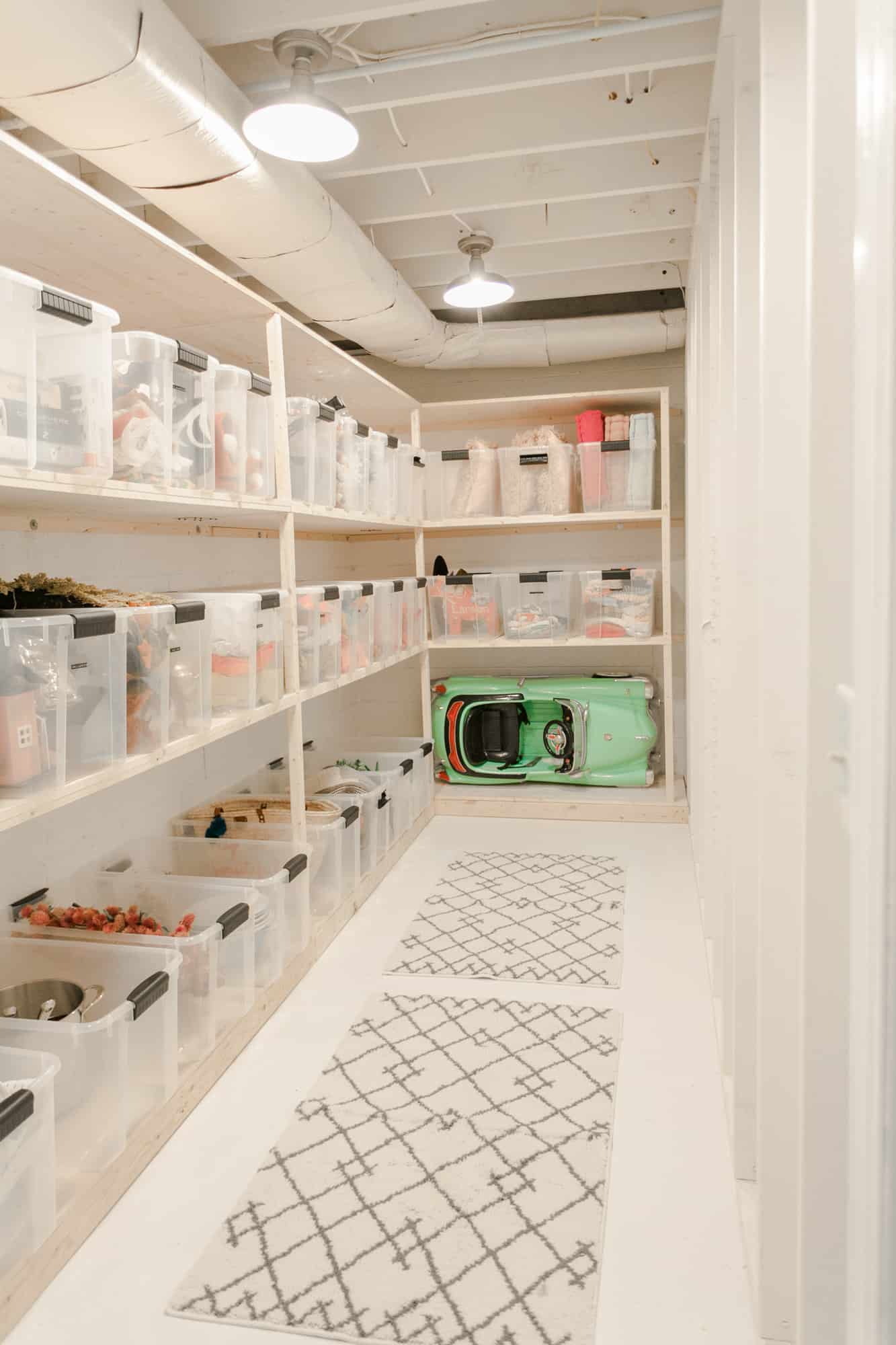storage room with white walls and shelves of clear bins
