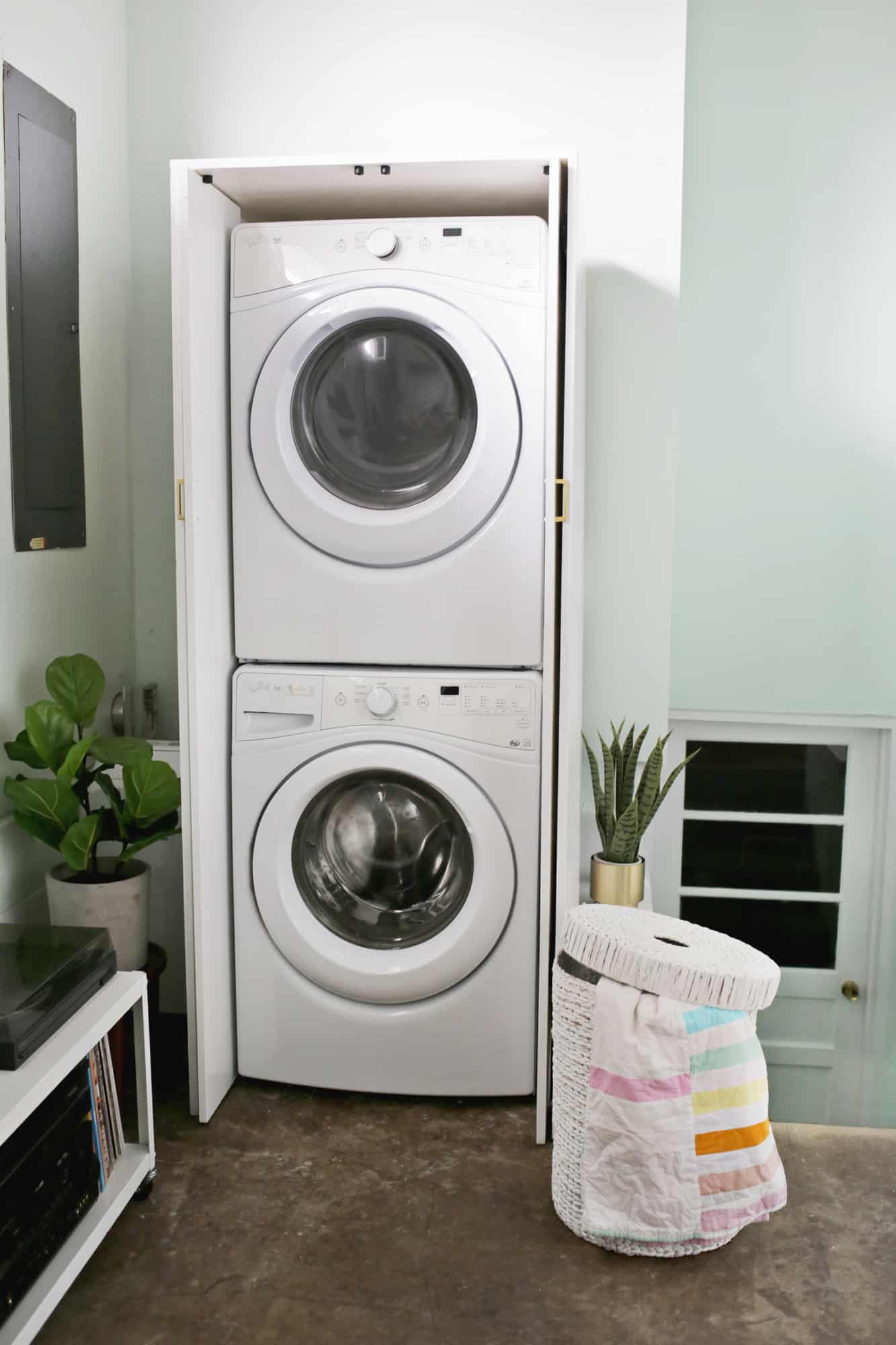 a white cabinet with a stacked washer and dryer in it