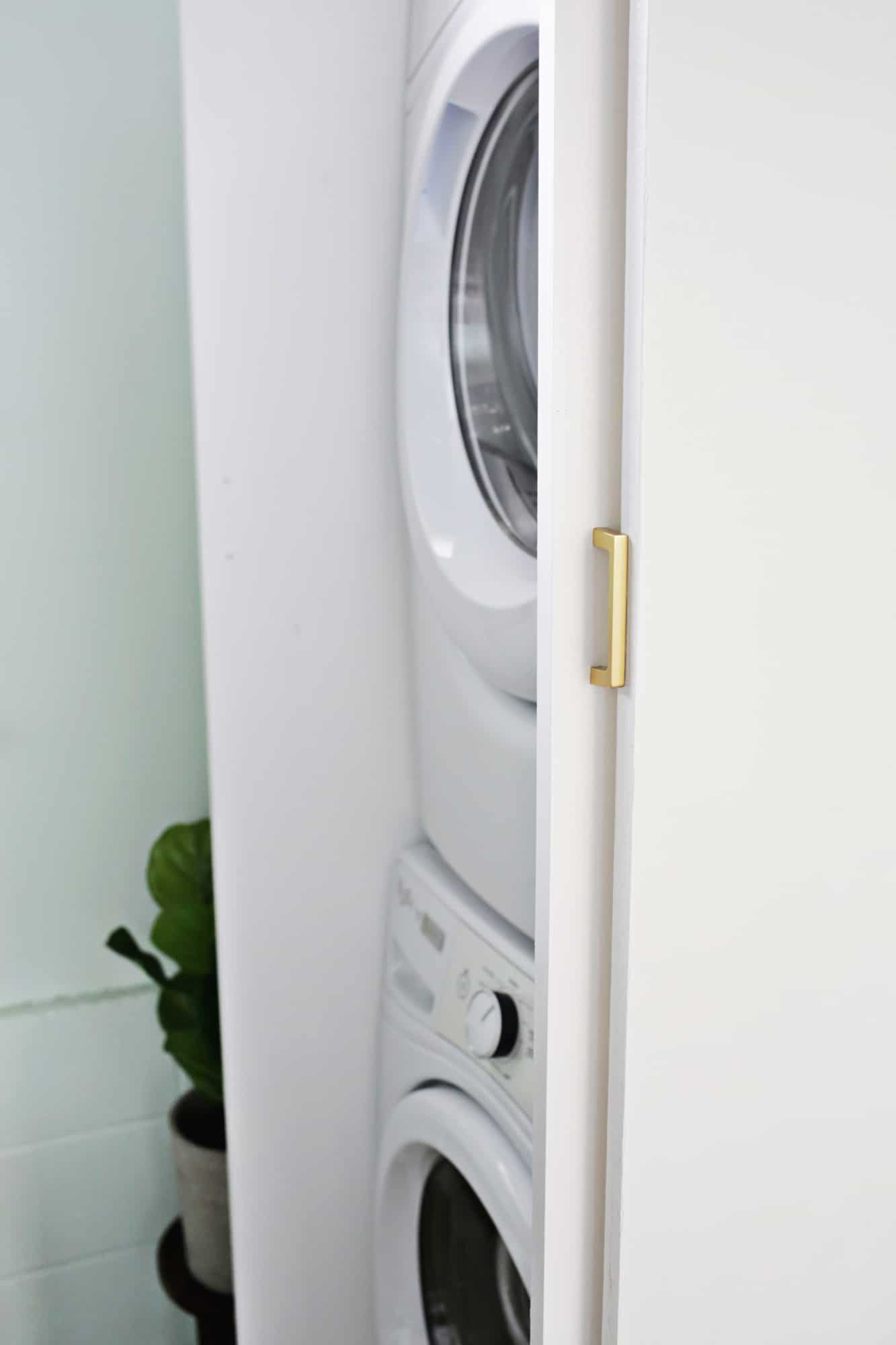 side view of white cabinet with stacked washer and dryer in it