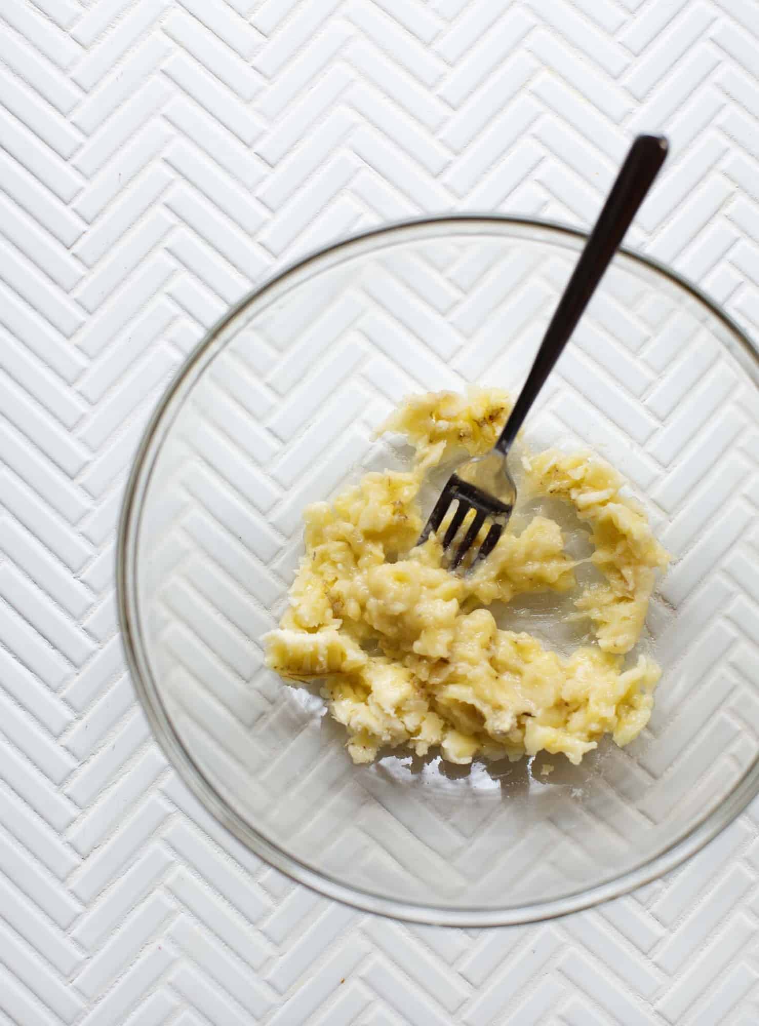mashed banana in a bowl with a fork