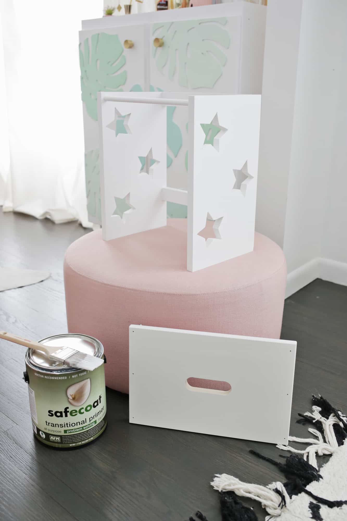 white painted box with stars cut out of it on a pink ottoman