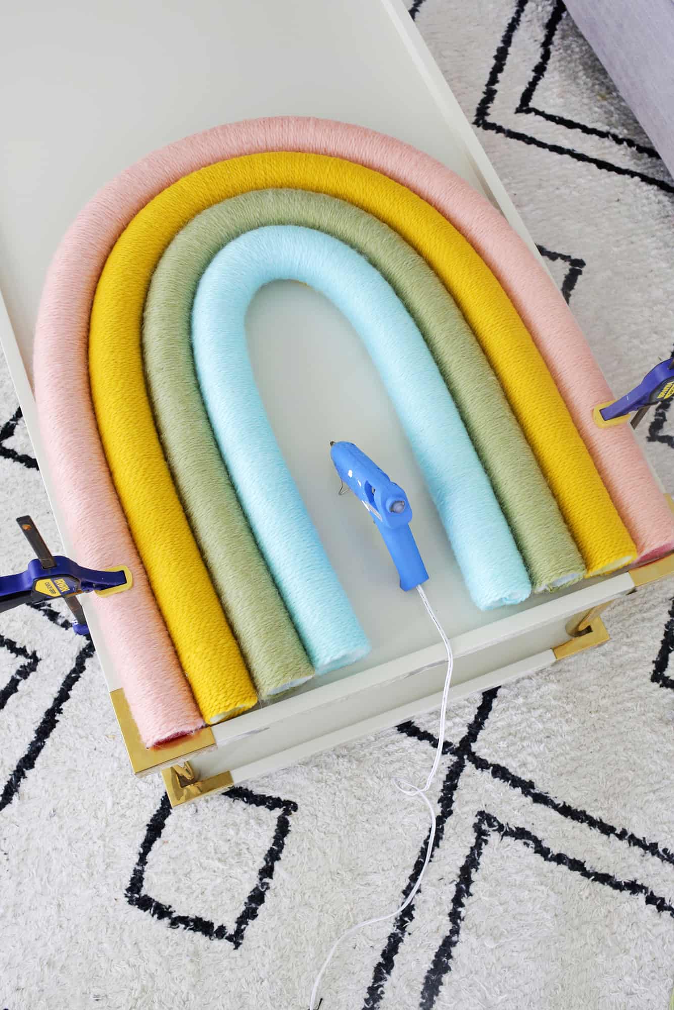4 yarn wrapped pool noodles  and a glue gun on coffee table