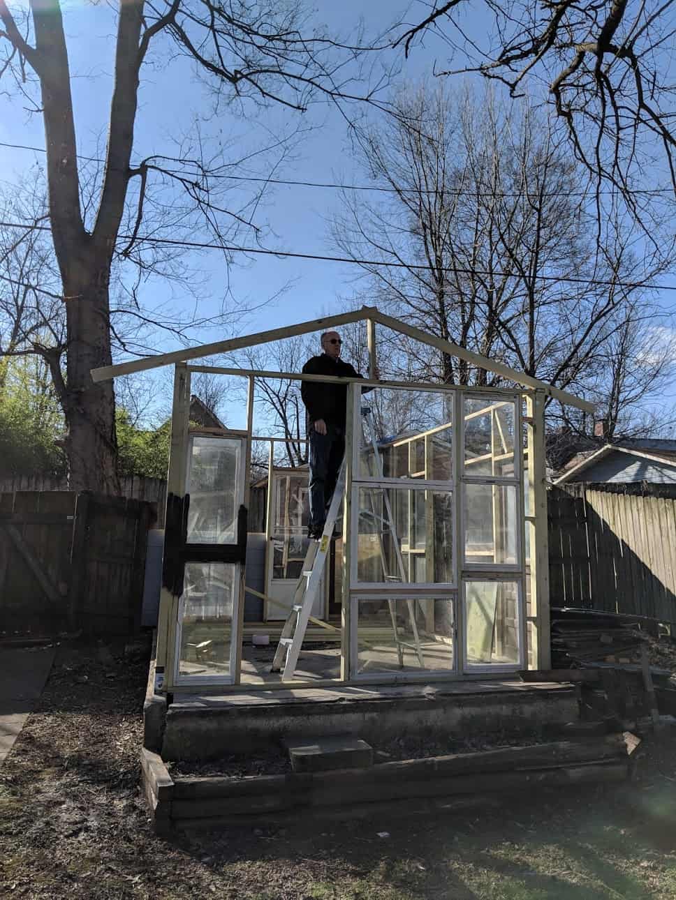 a man building the wood frame of the greenhouse