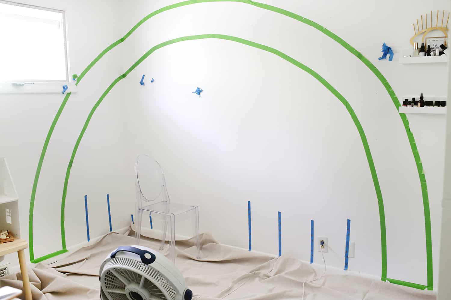 green painters tape outling the loop of the rainbow on the wall