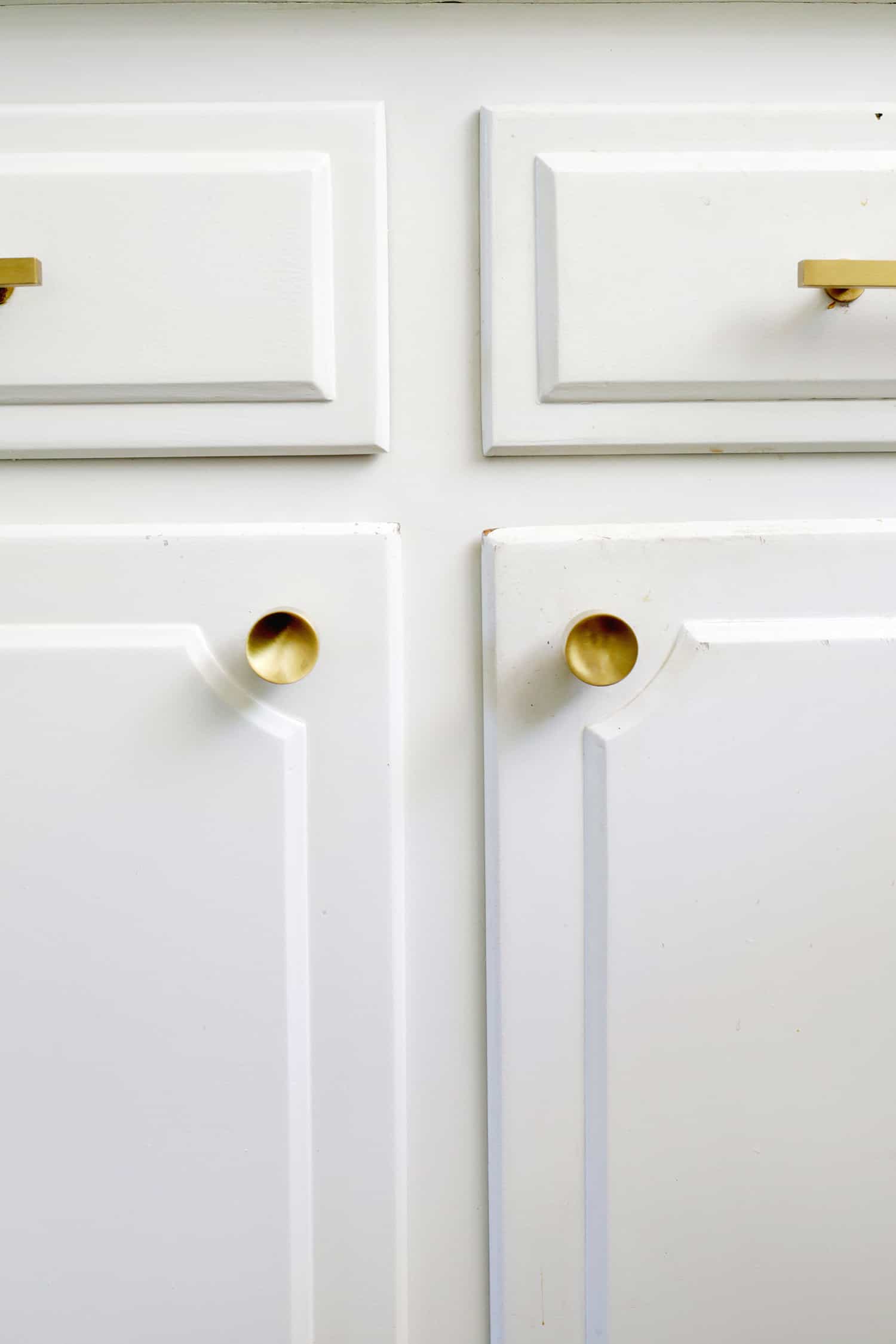 white kitchen cabinets with gold knock