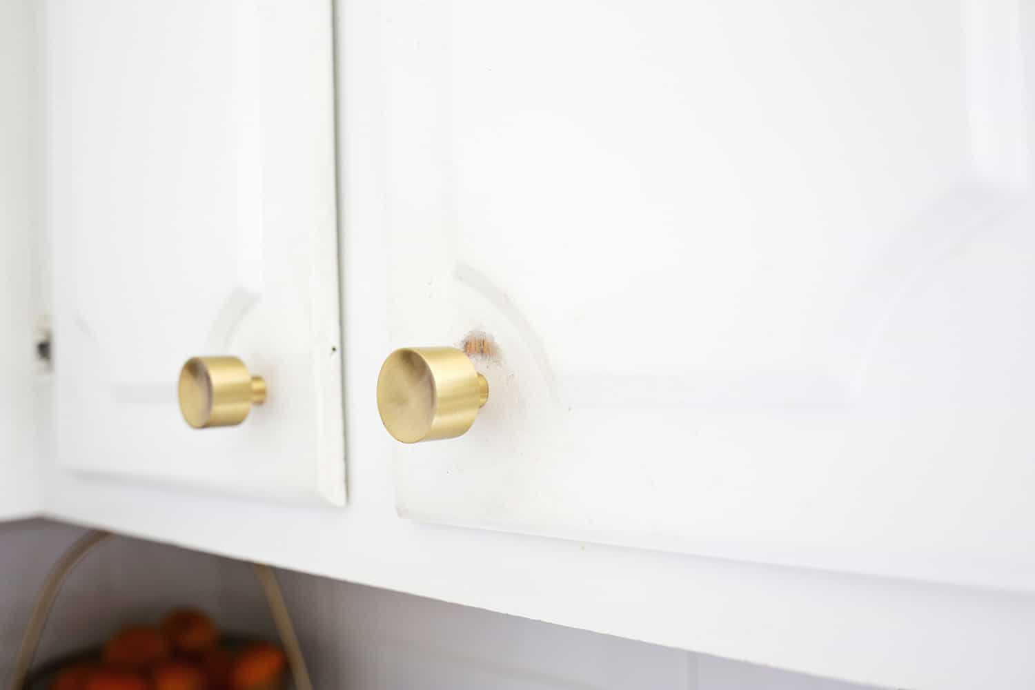 white kitchen cabinets with gold knock