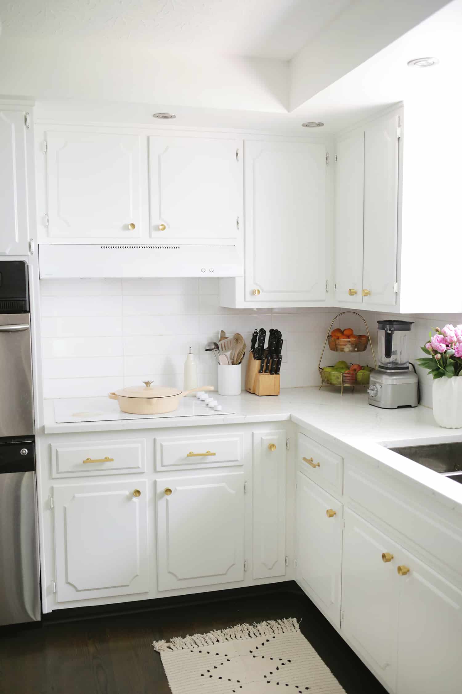 wider view of white kitchen with gold handle