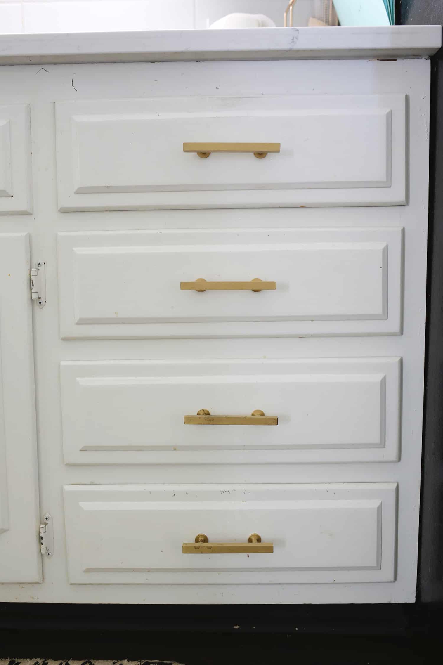 white kitchen drawers with gold handles