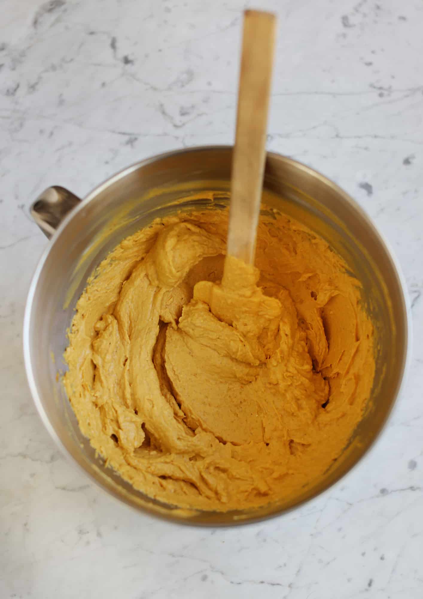 pumpkin puree in mixing bowl with spatula in it