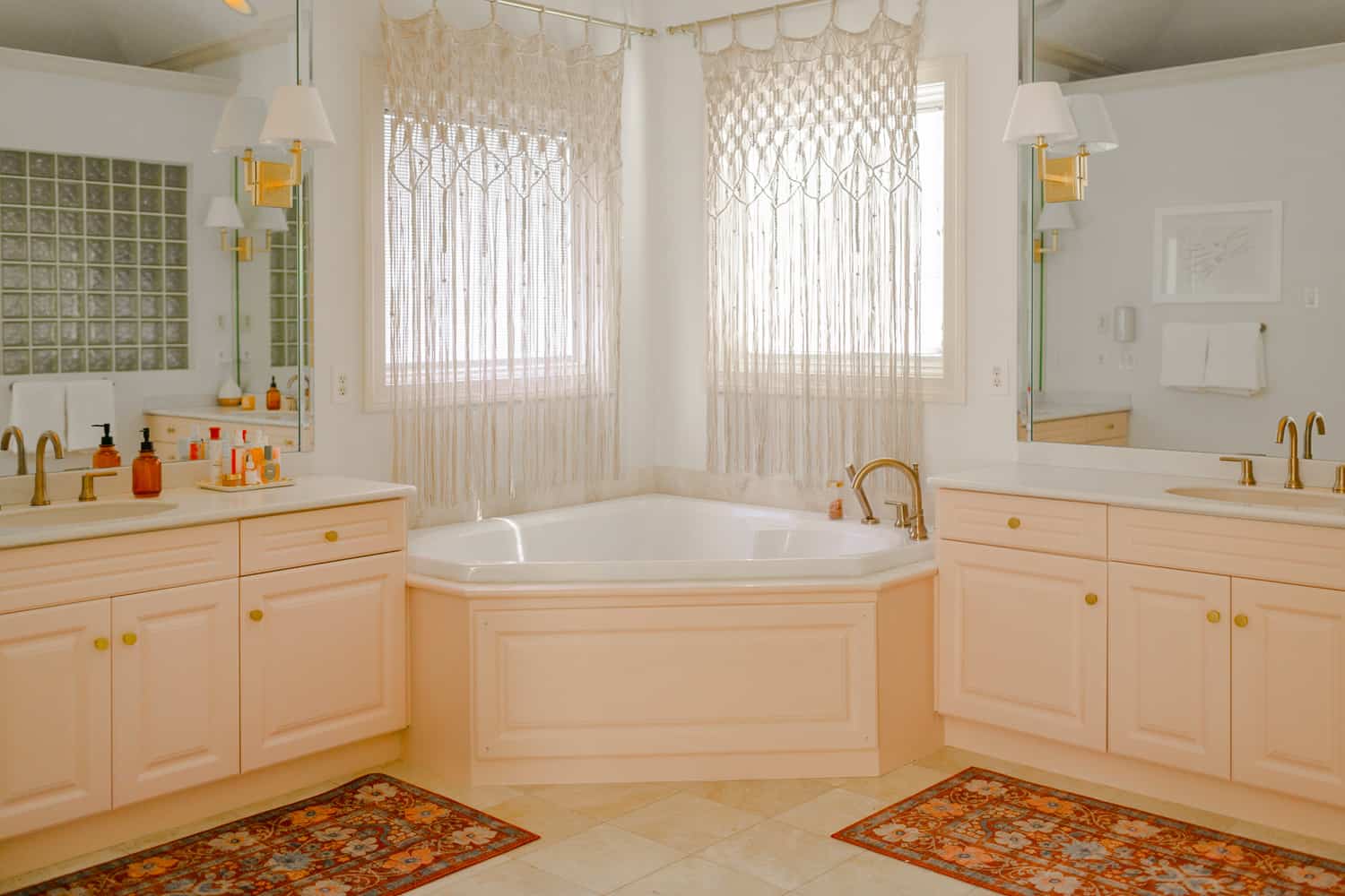 a tub between two pink vanities
