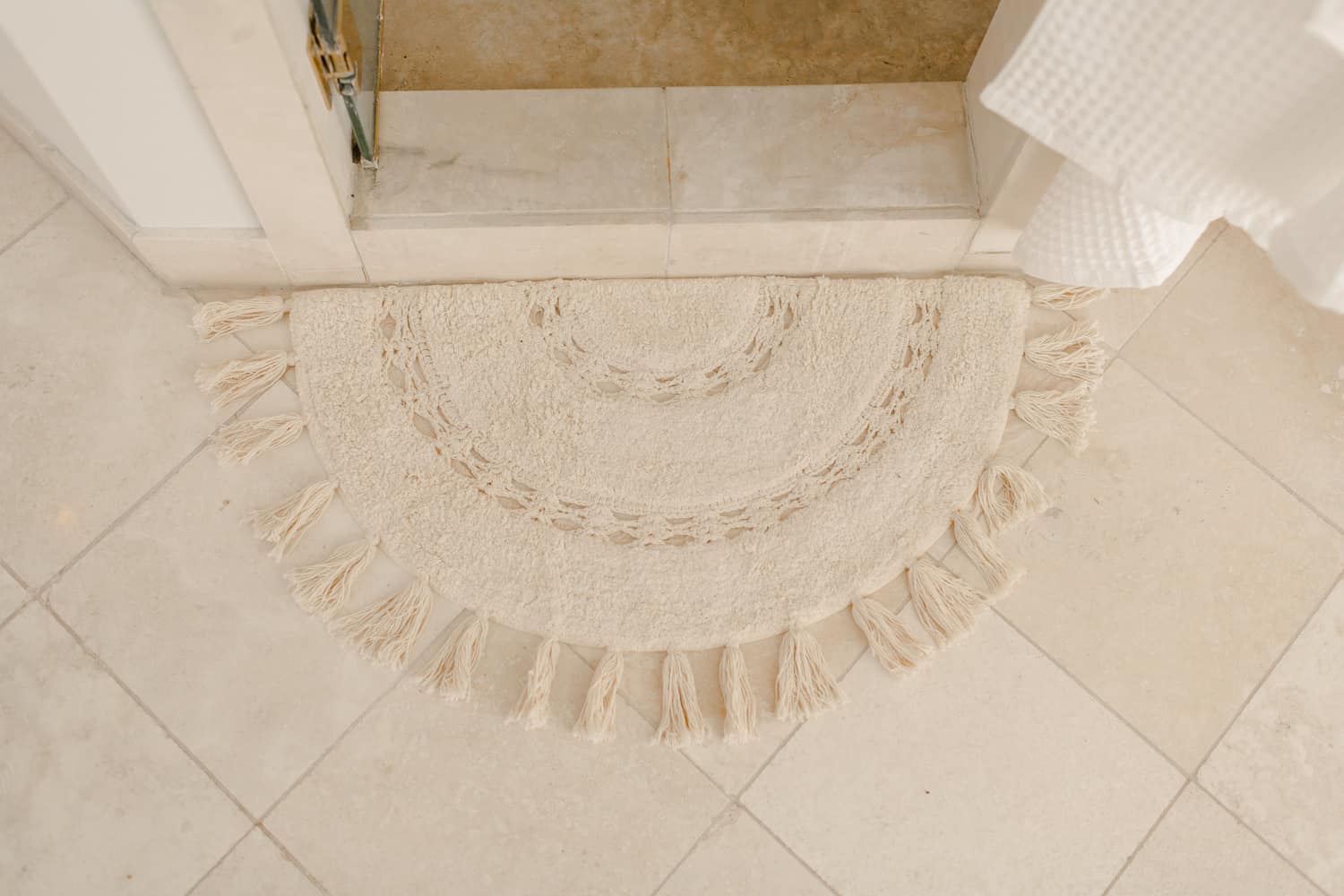 a white rug in front of the shower