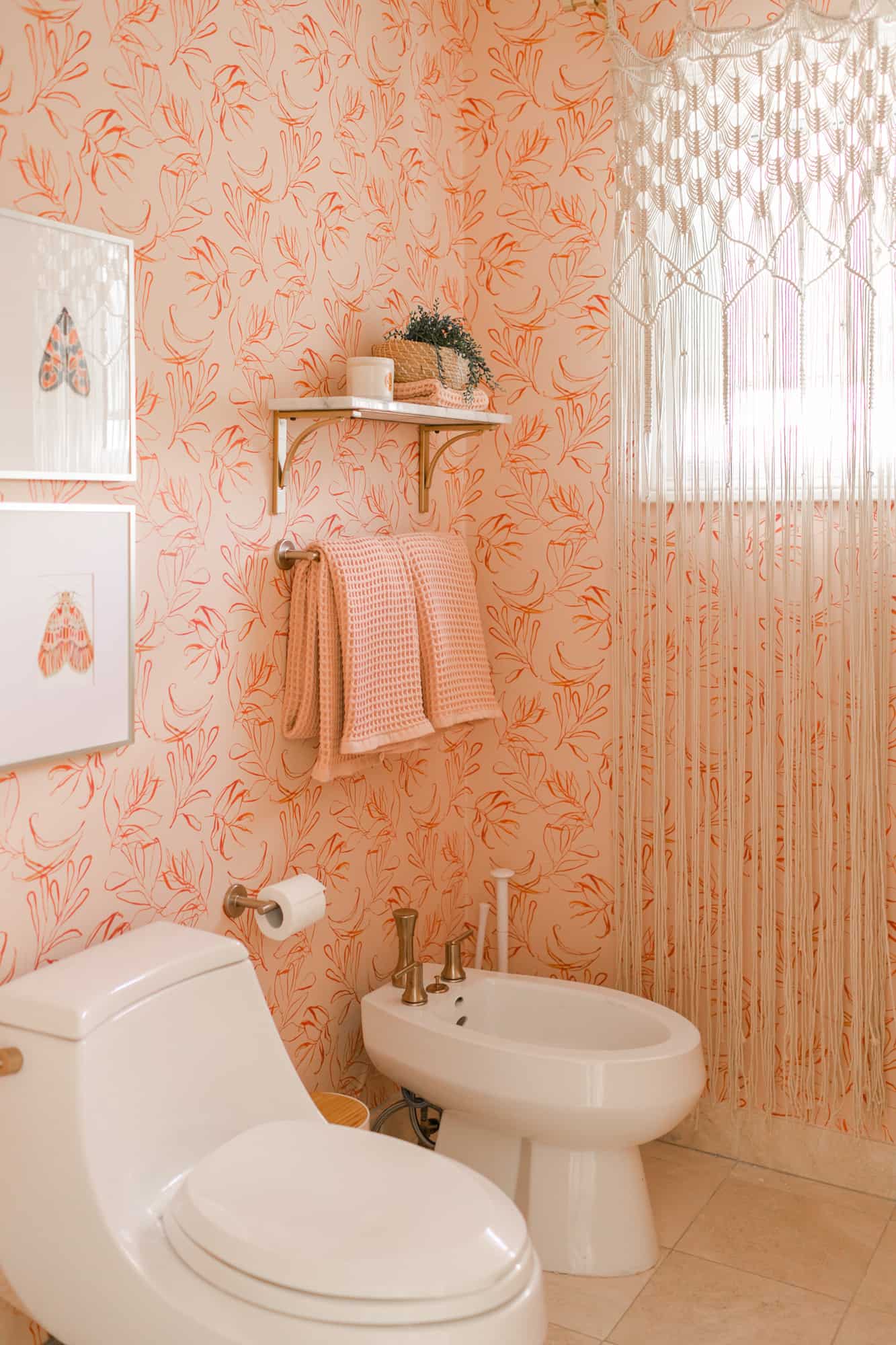 pink with flowers wallpaper in a bathroom with a toilet and bidet