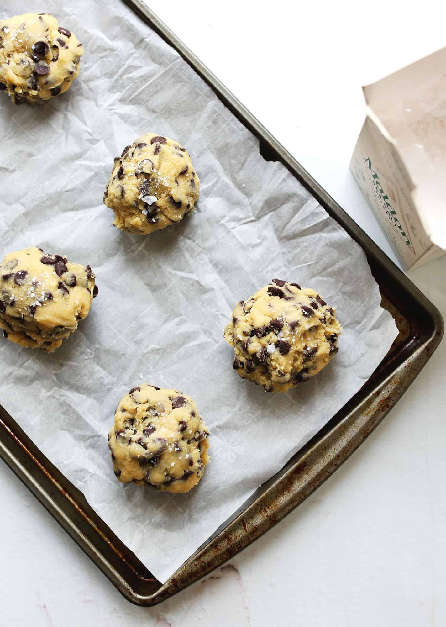 rolled balls of cookie dough on a baking sheet
