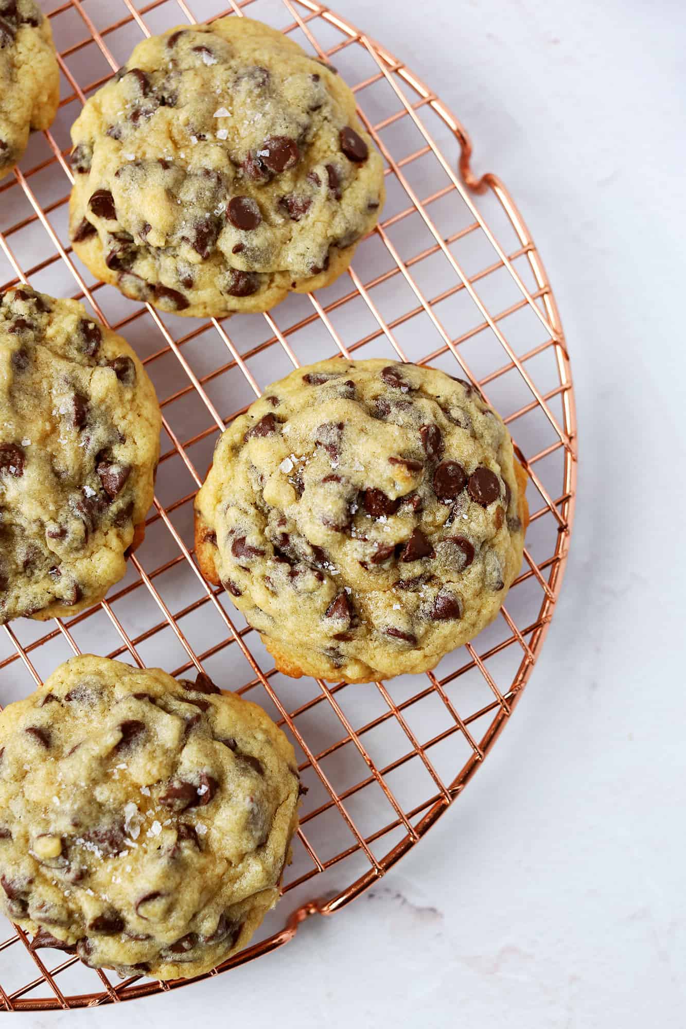 oversized soft center chocolate chip cookies on a cooling rack