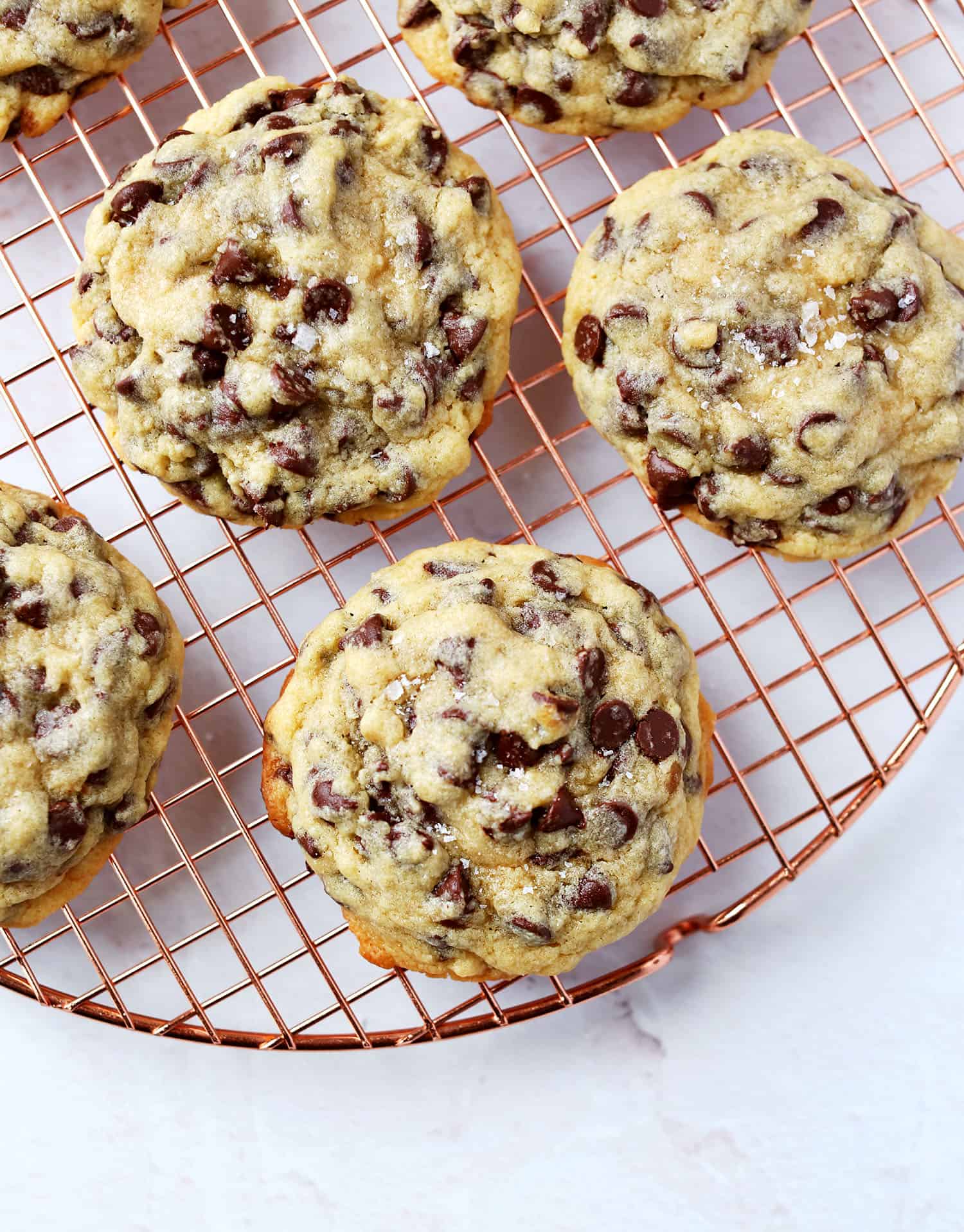 oversized soft center chocolate chip cookies on a cooling rack