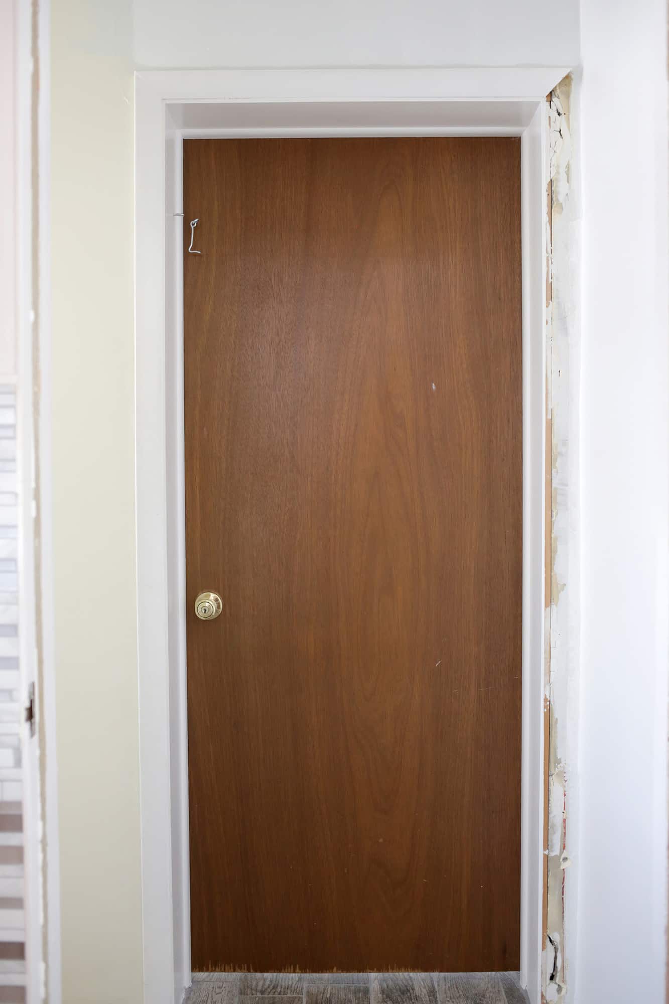 brown door with old hardware and chipped bottom