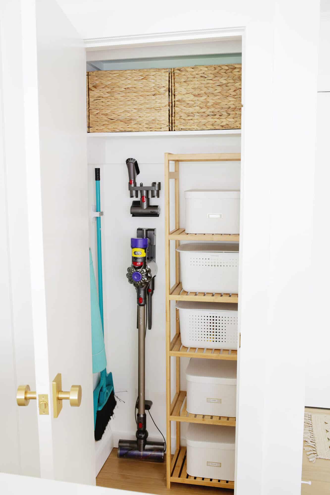 Organized closet with hanging cleaning items and baskets