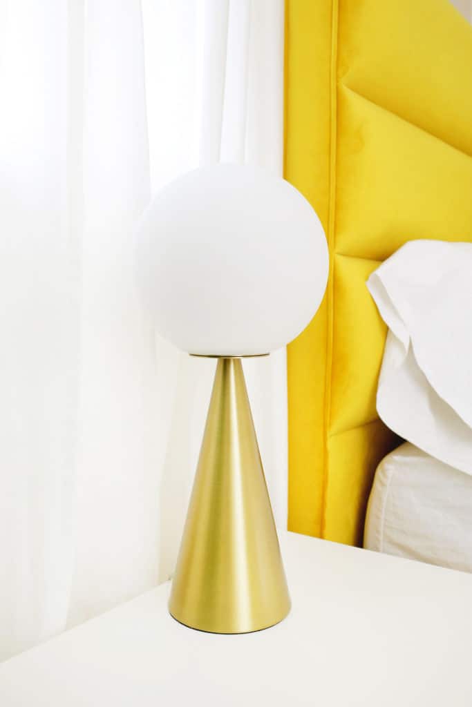 cone shaped gold lamp on nightstand