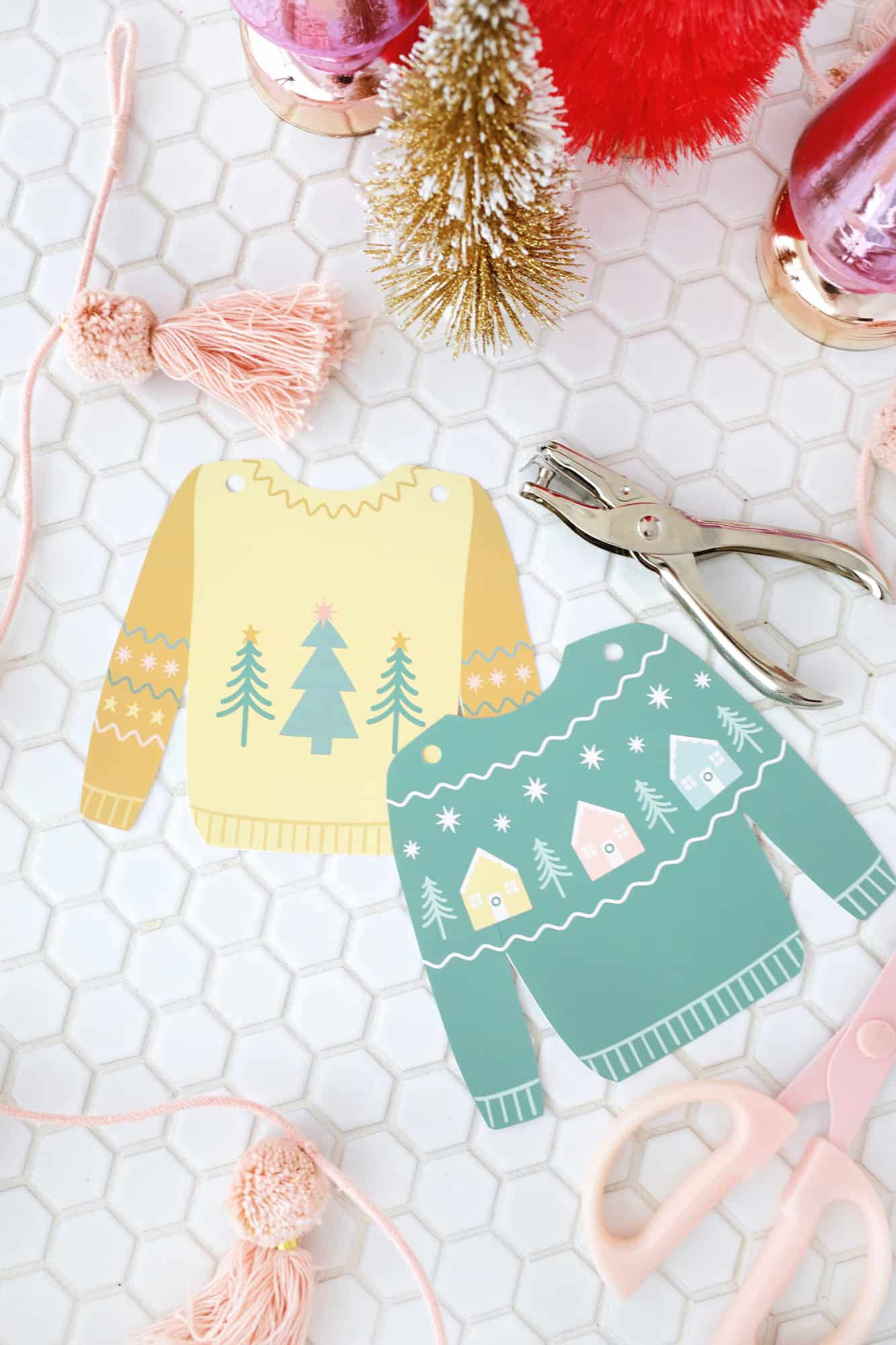 Paper Christmas sweaters punched with a hole punch at the top