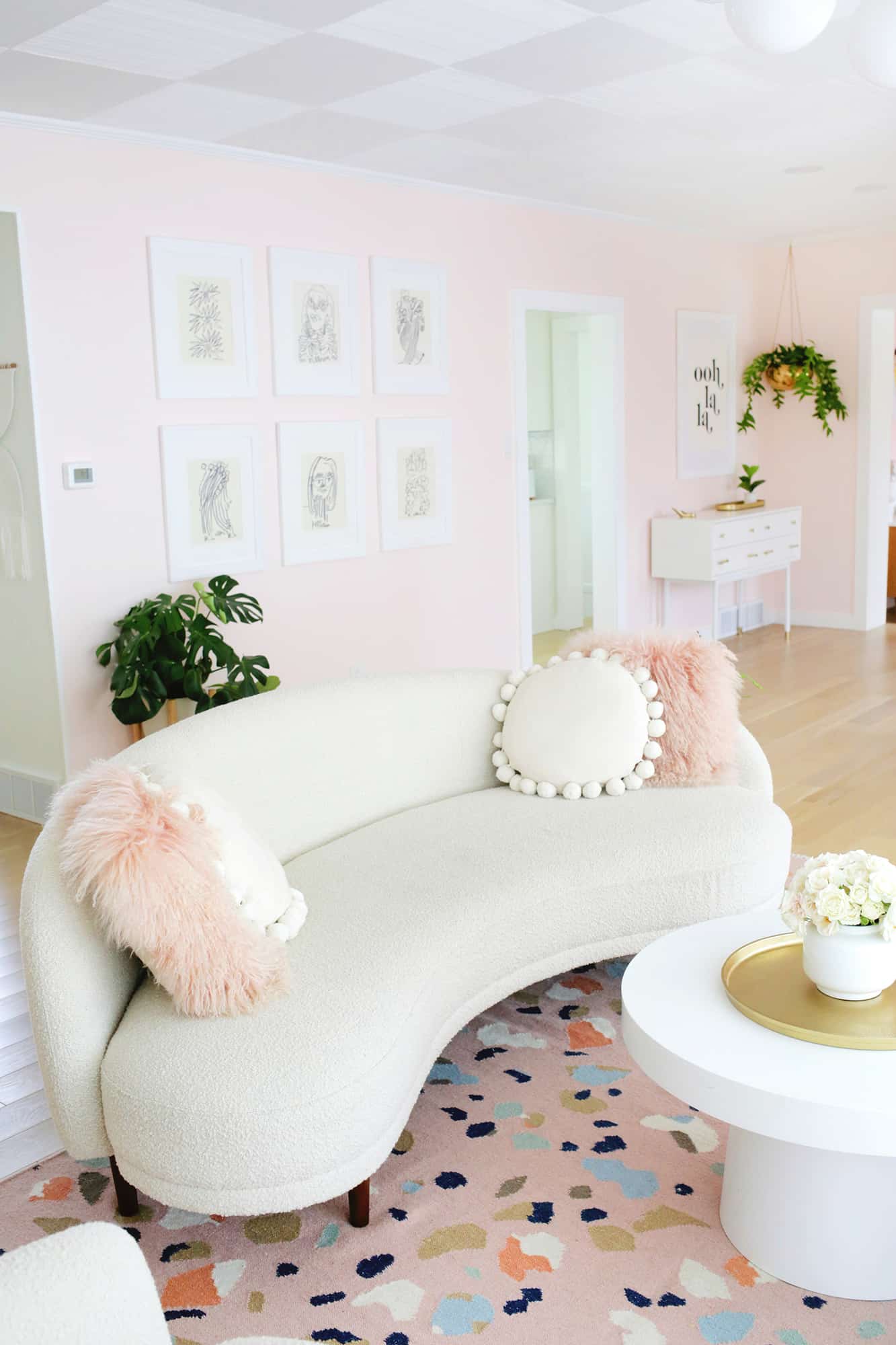 white boucle couch with pink pillows