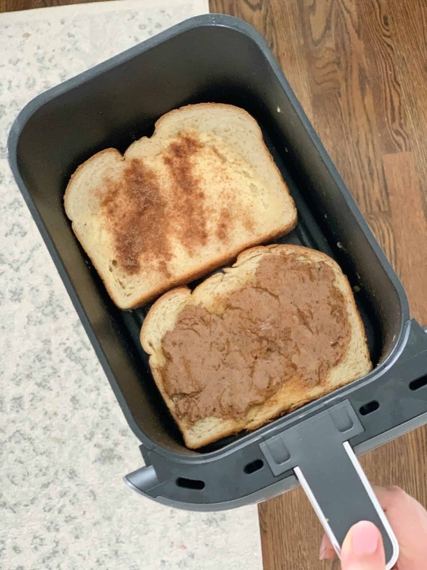 two slices of bread in an air fryer basket.