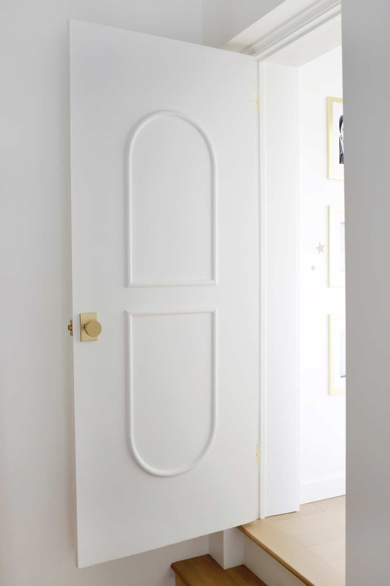 open door with brass hardware and arched trim
