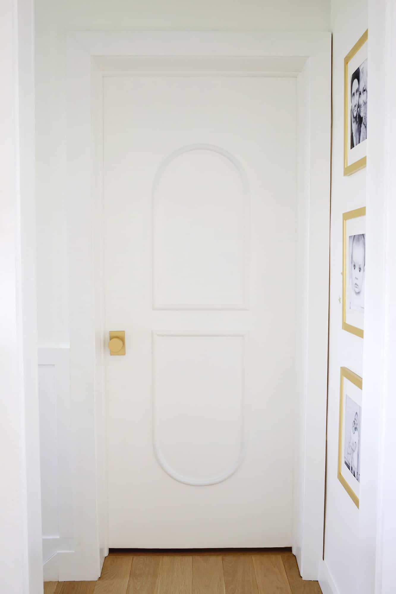 door with brass hardware and arched trim