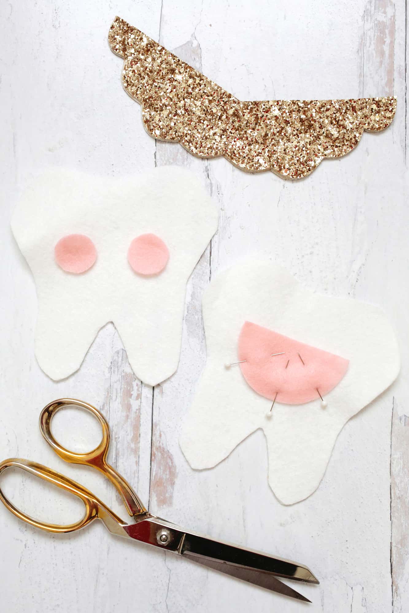 White tooth pillow cutouts with pink cheeks and pocket on back pinned in place