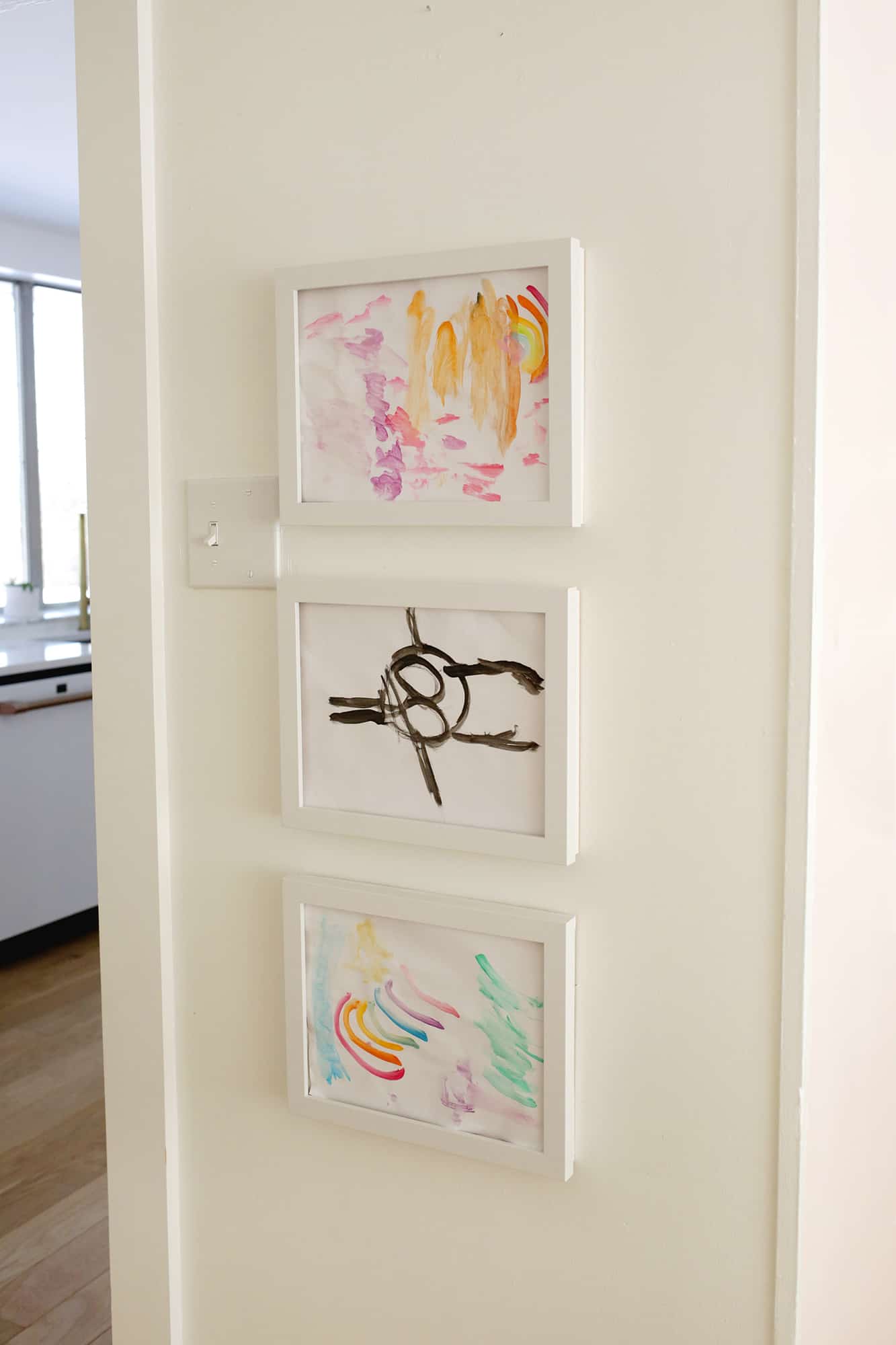 Kid's art display frames hanging on wall with kid's art inside frames