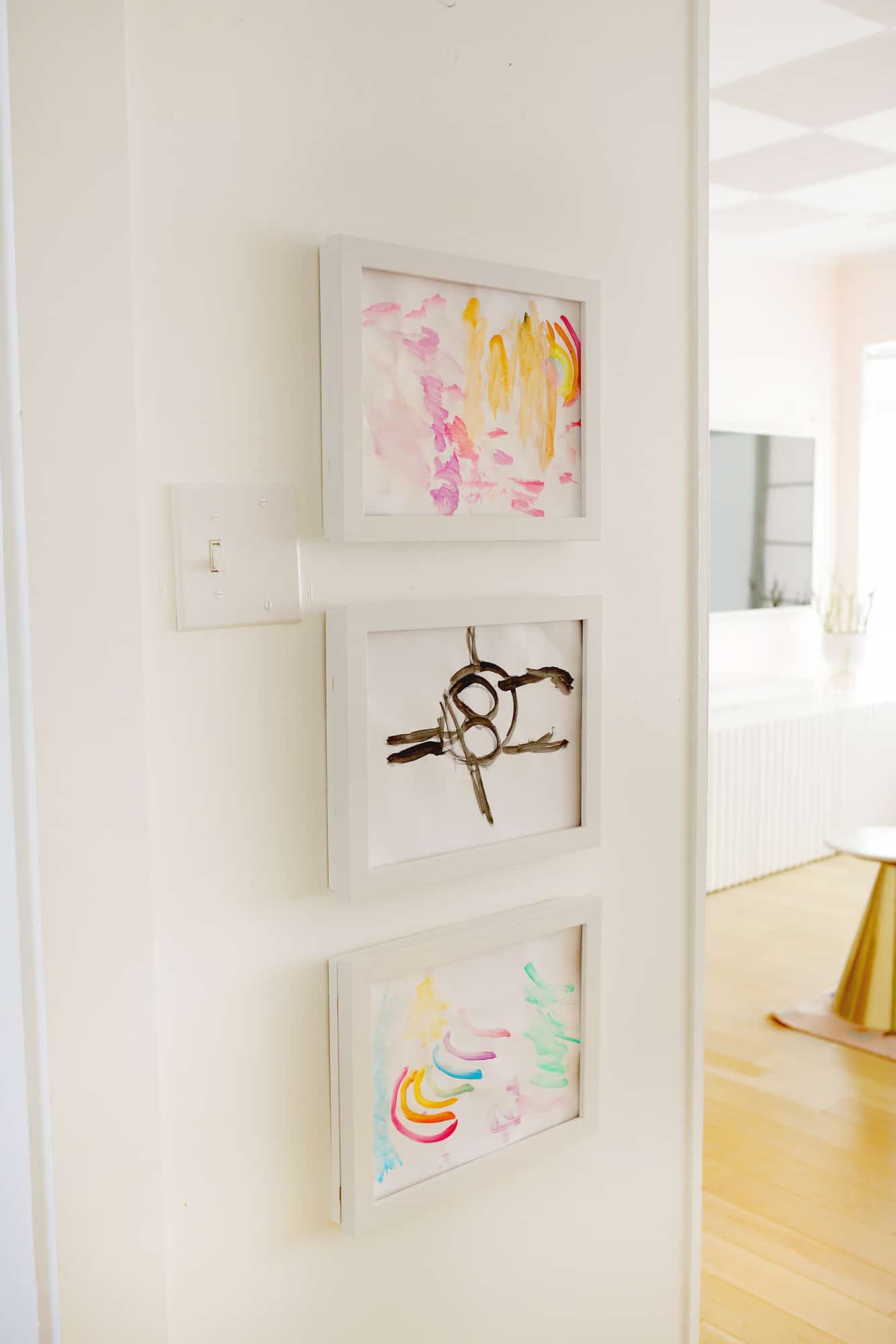 Kid's art display frames hanging on wall with kid's art inside frames