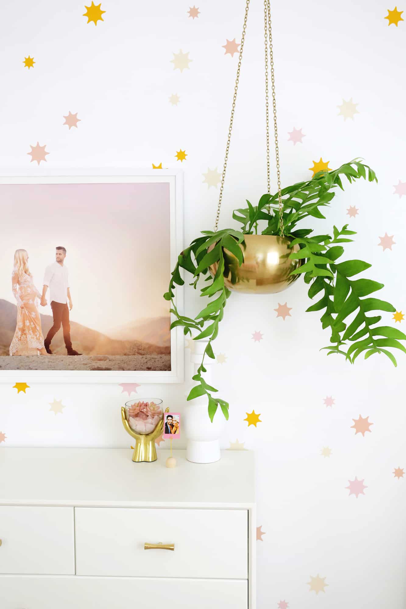 star wallpaper with a dresser and hanging plant