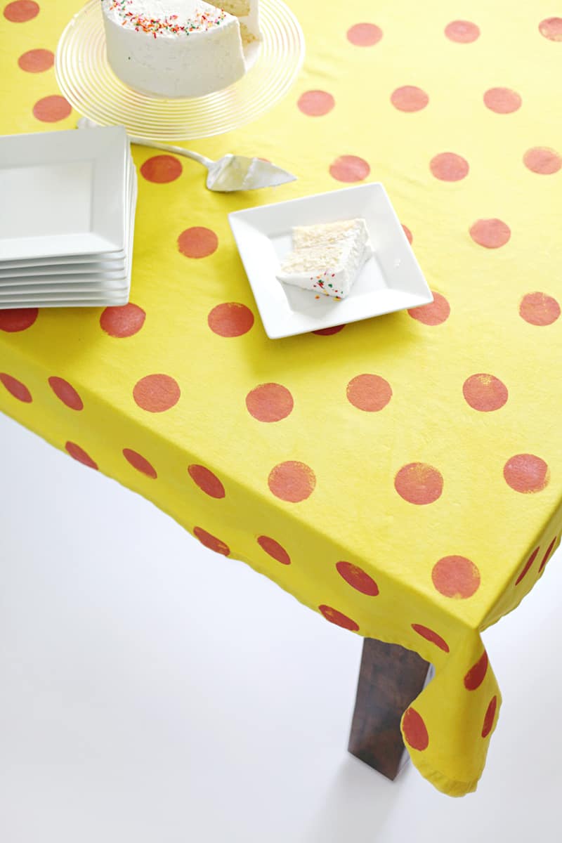 a yellow tablecloth with red stamped dots