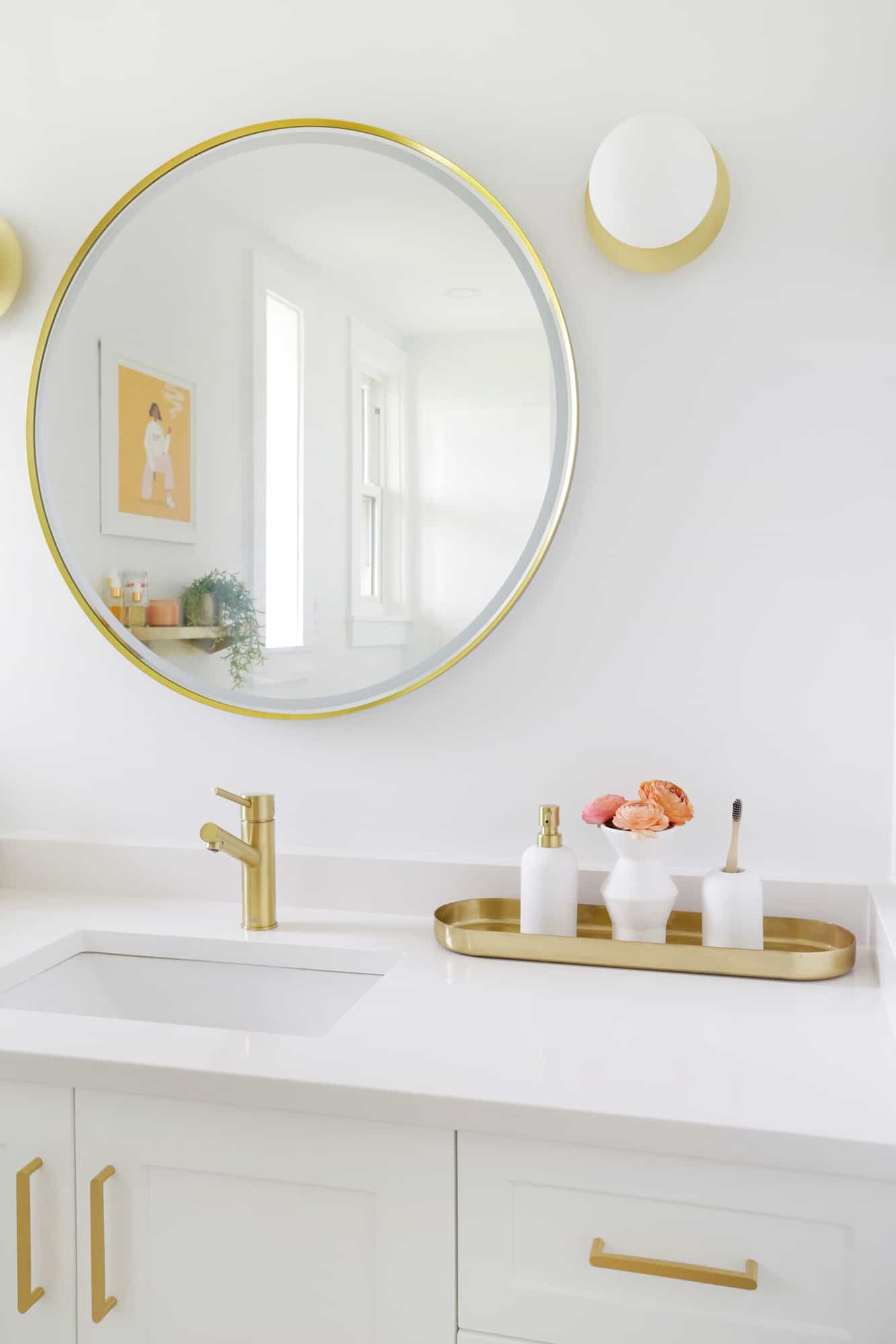Bright bathroom with gold fixtures, gold tray with flowers