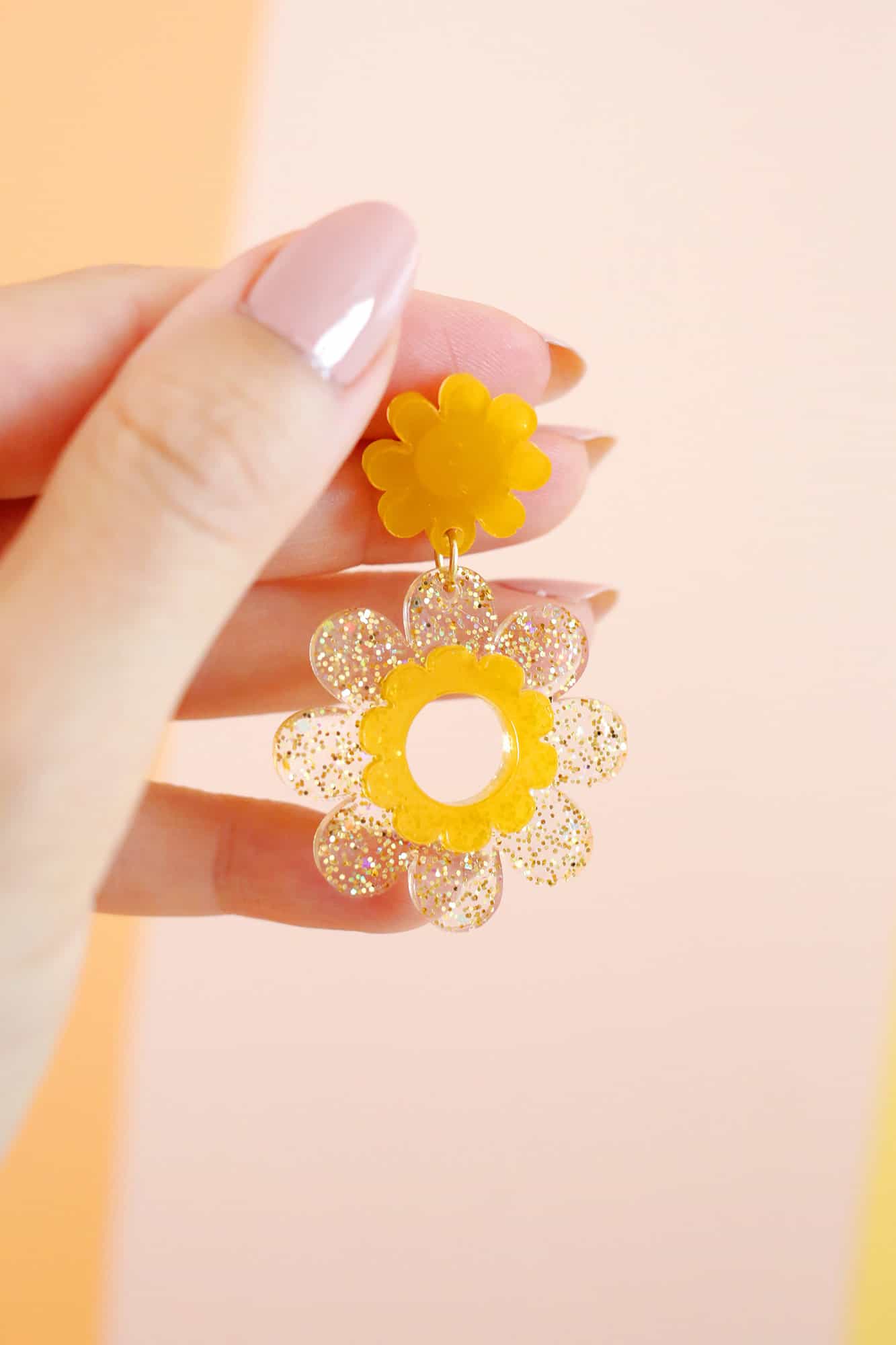 hand holding a glitter diy daisy earring