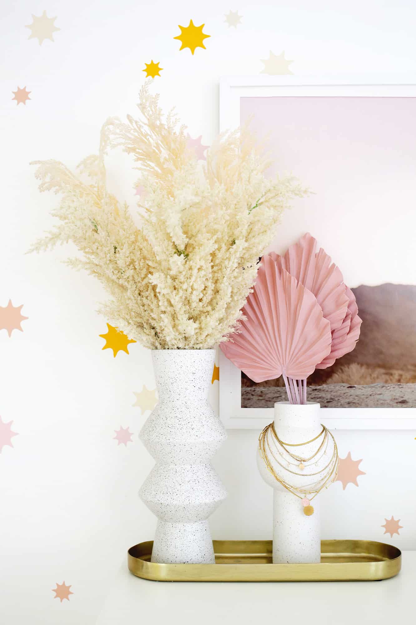 grasses in a tall vase in front of star wallpaper